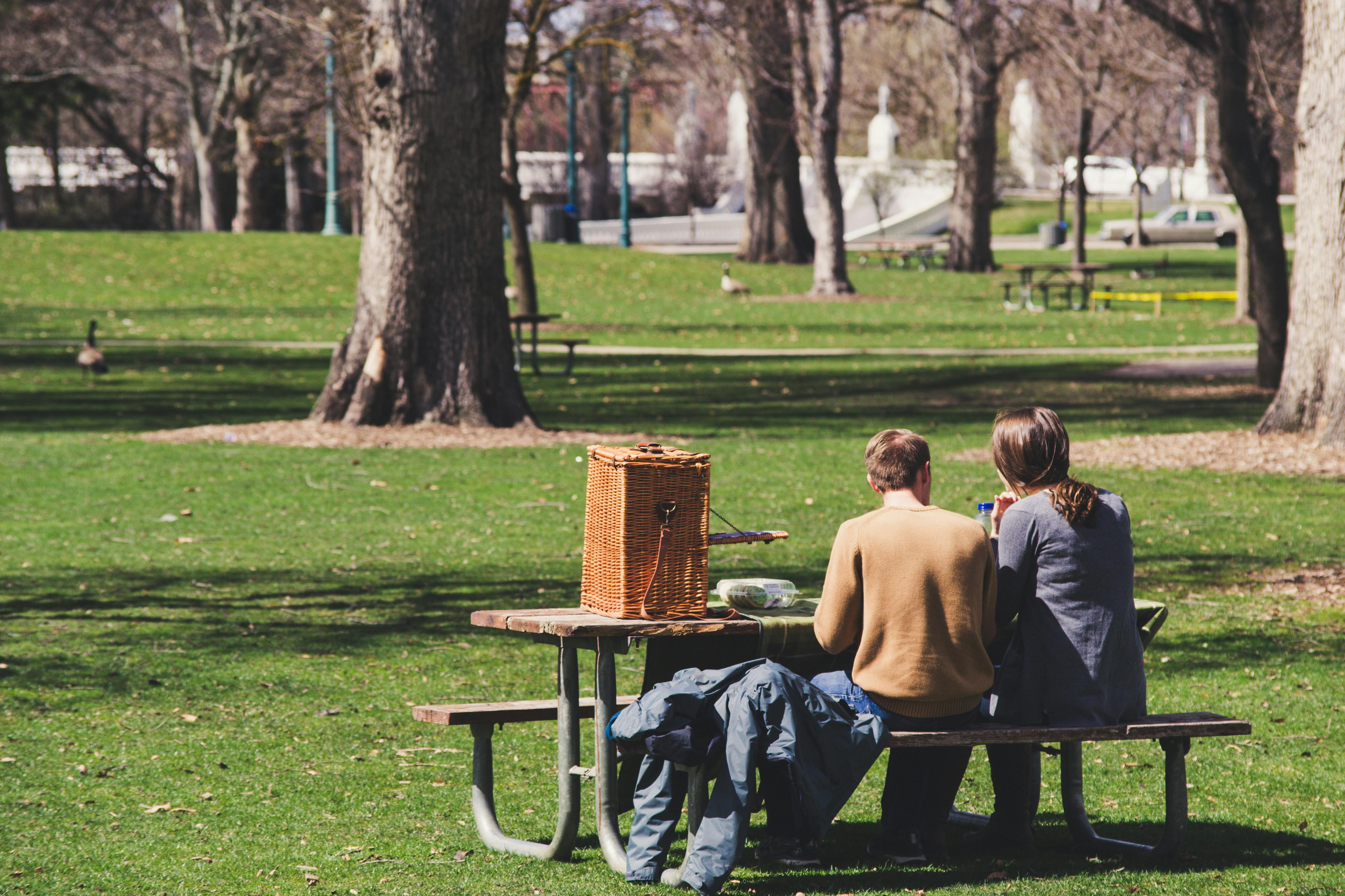 Un hombre y una mujer sentados en una mesa de picnic | Foto: Pexels