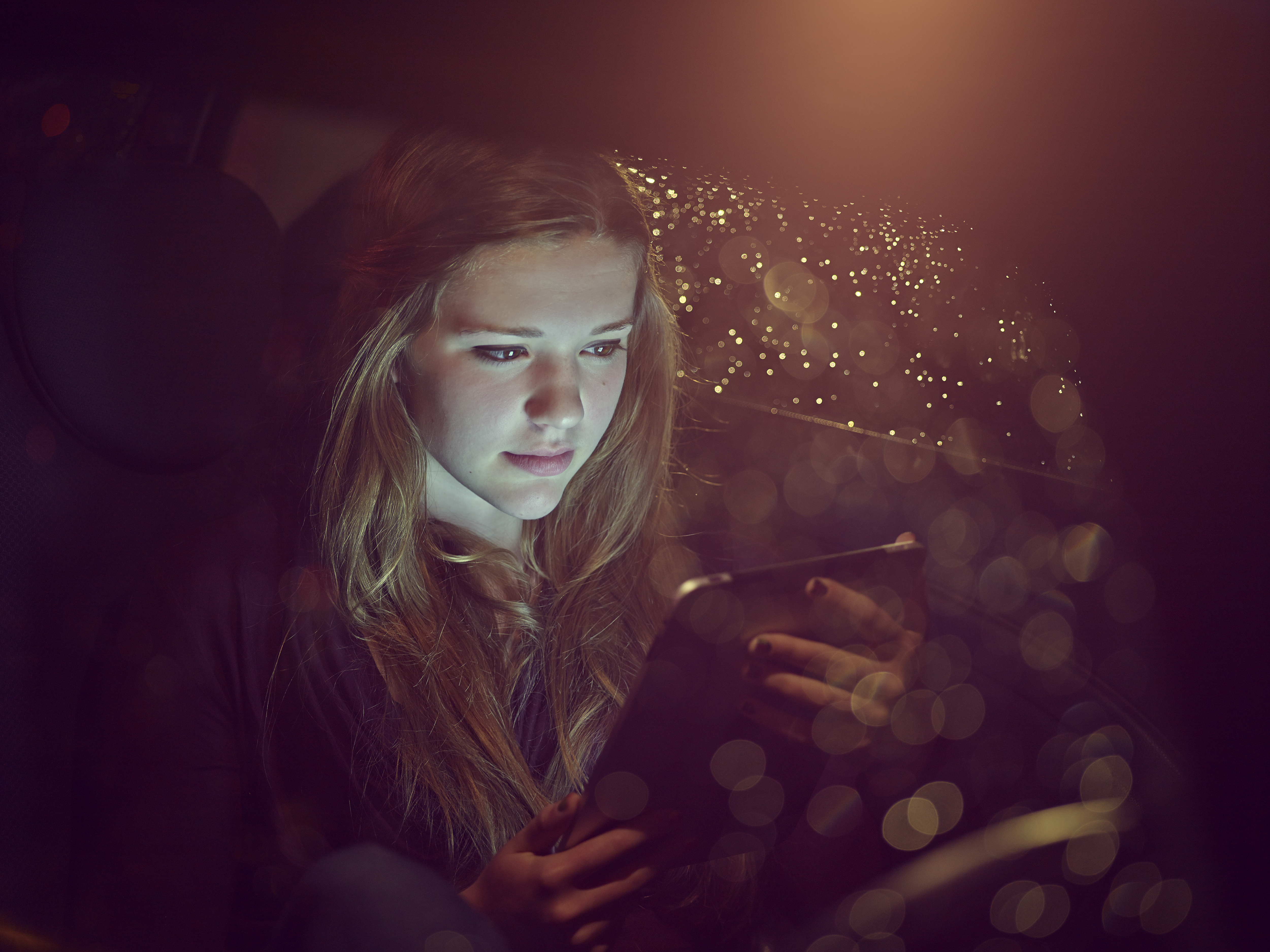 Adolescente en una tablet en un automóvil de noche | Foto: Getty Images