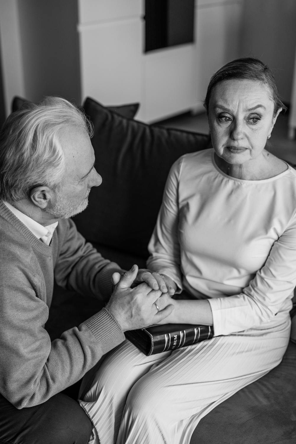 Una mujer mira hacia otro lado mientras su marido la consuela ⏐ Fuente: Pexels