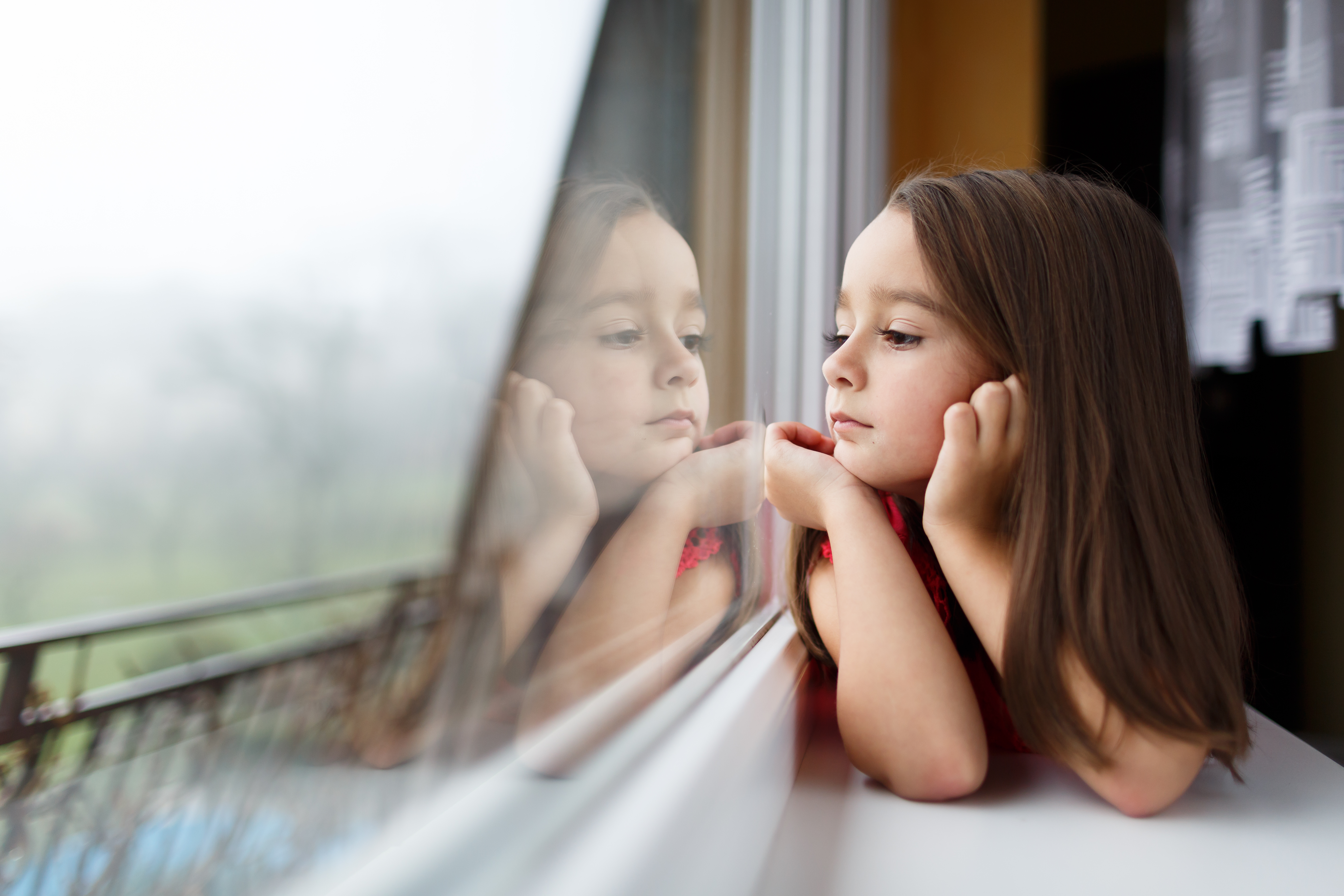 Niña mirando por la ventana | Foto: Shutterstock