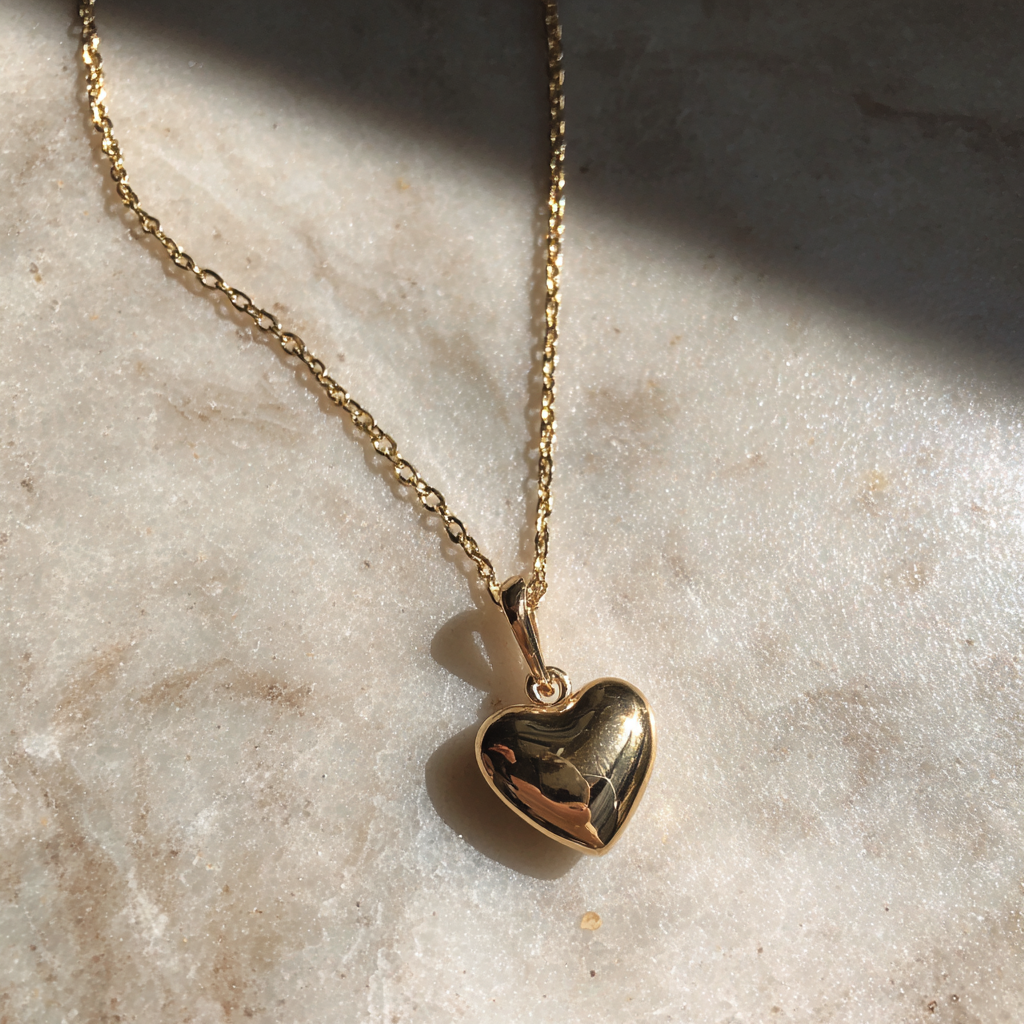 Una delicata collana d'oro su un bancone | Fonte: Midjourney