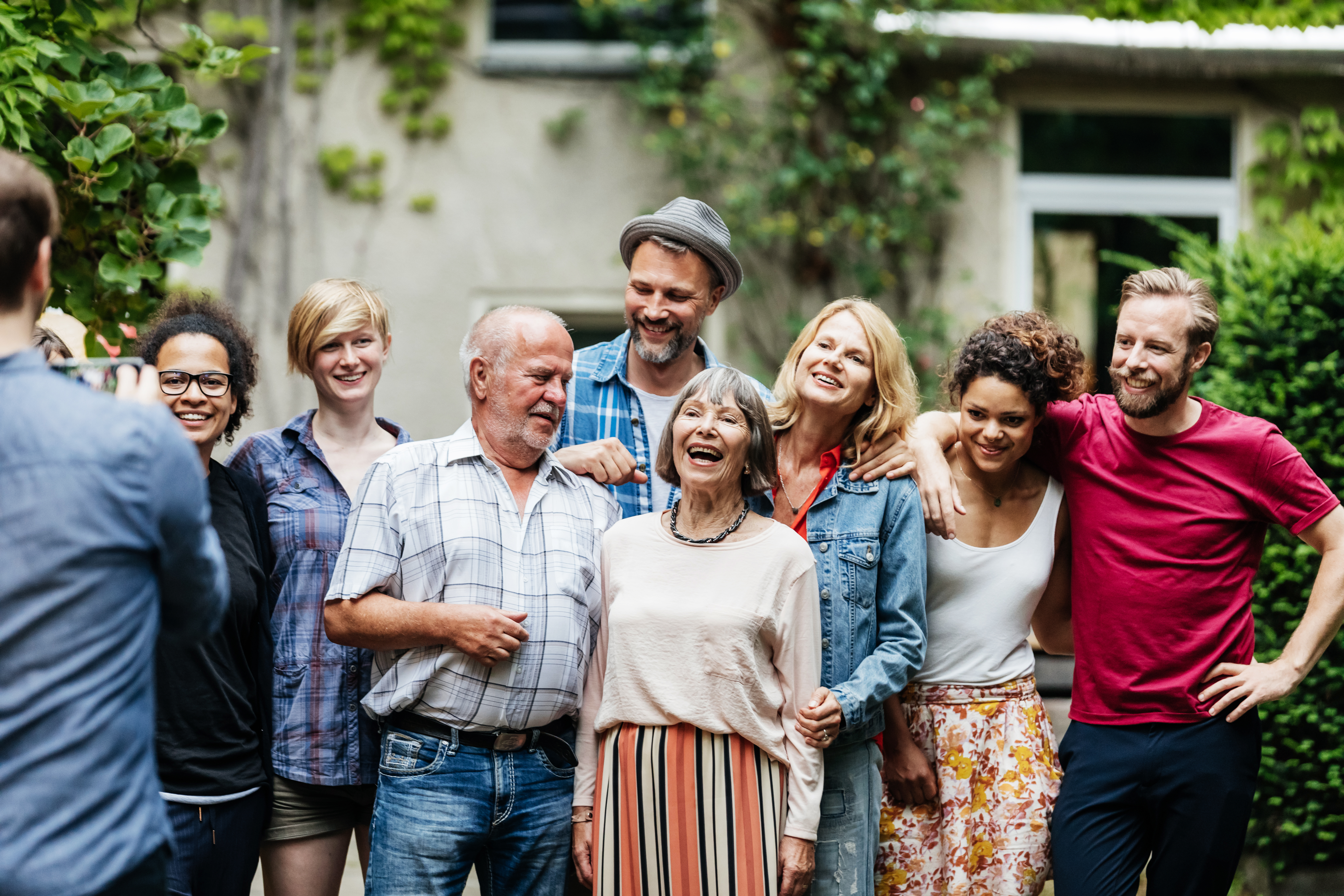 Hombre haciendo una foto de grupo a su familia en una barbacoa | Fuente: Getty Images