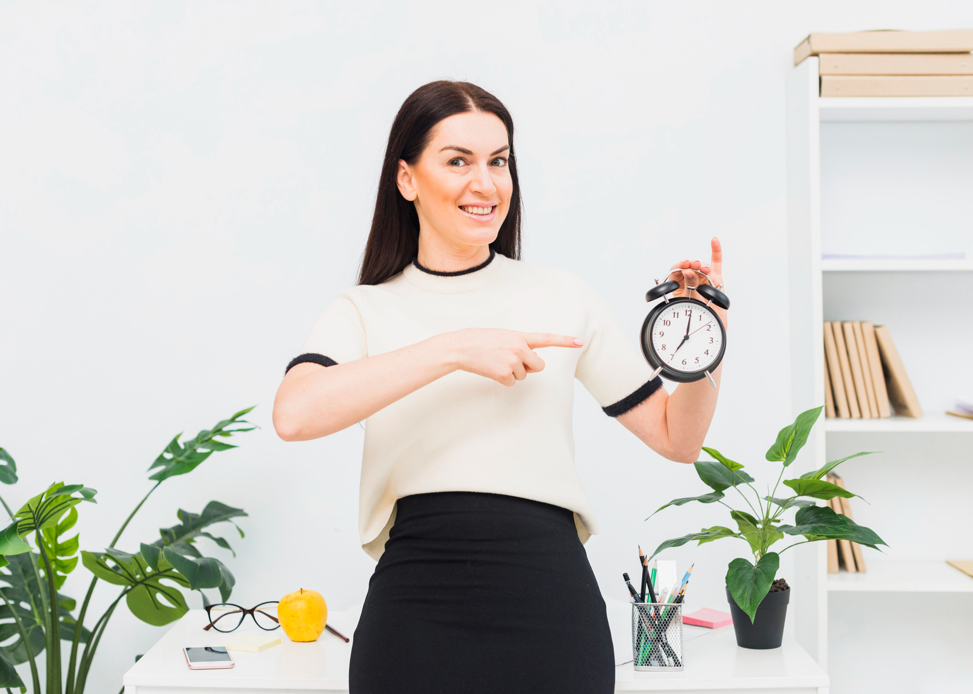 Una mujer señalando un reloj con la mano | Fuente: Freepik