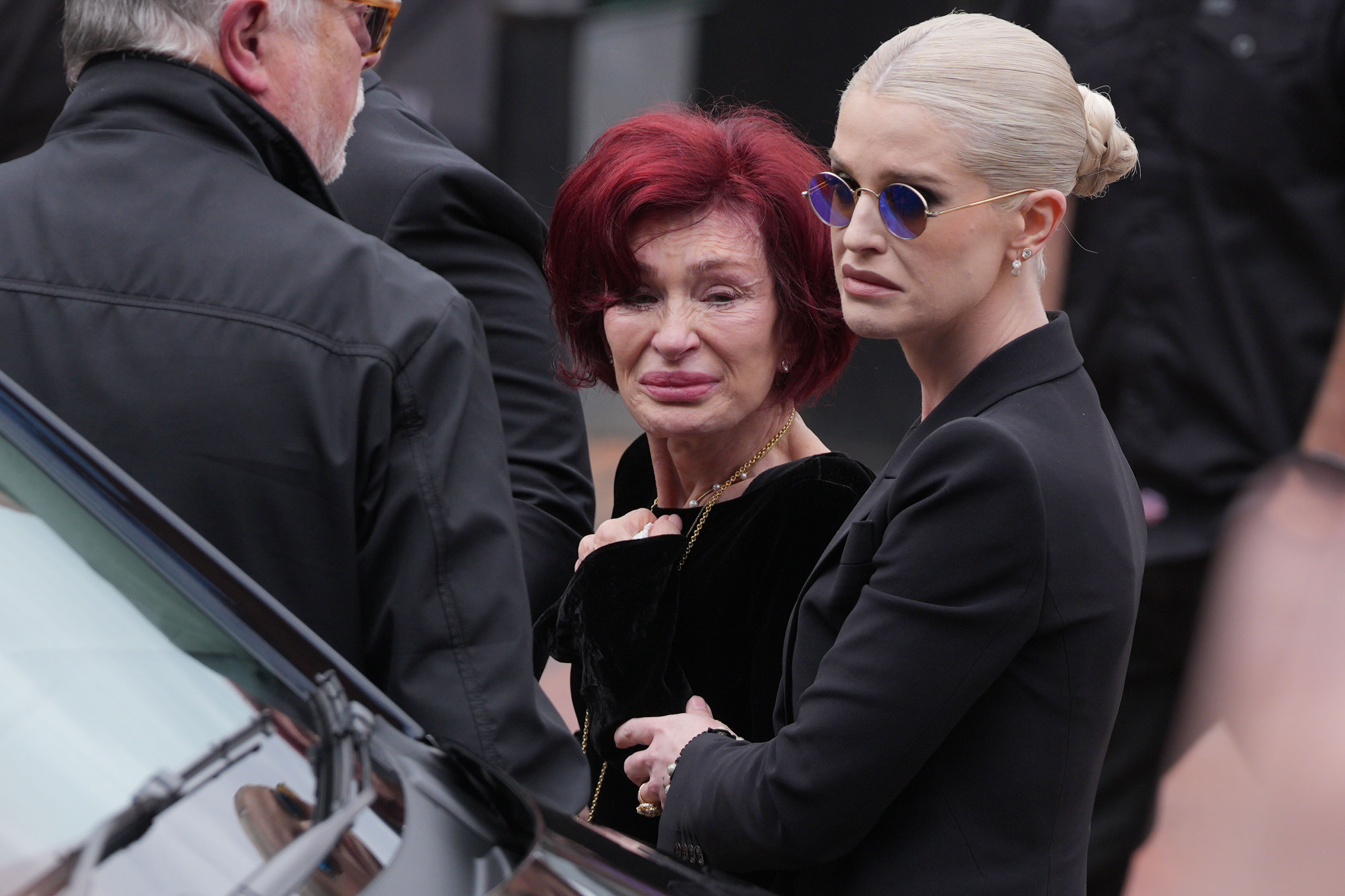 Sharon y Kelly Osbourne se detienen para ver los homenajes al fallecido Ozzy Osbourne el 30 de julio de 2025 en Birmingham, Inglaterra. | Fuente: Getty Images