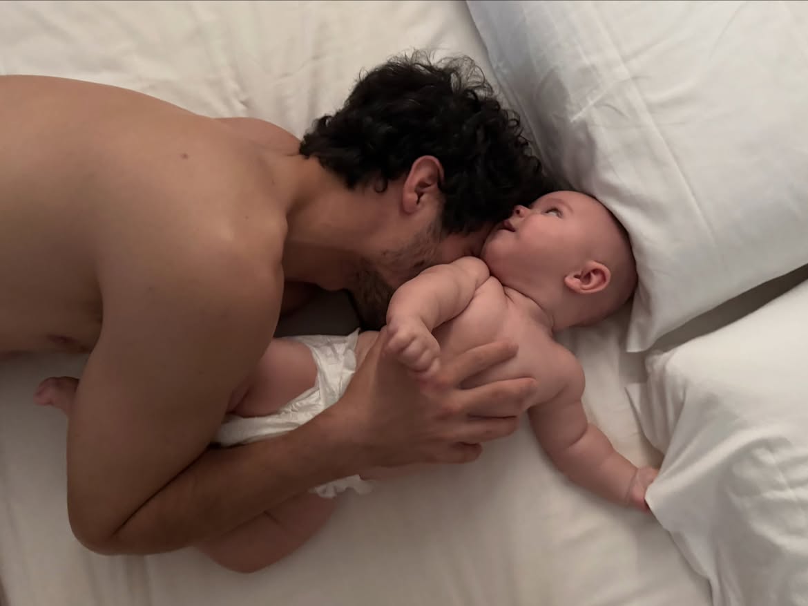 Chino Darín jugando con su hijo Dante recostado en una cama | Fuente: Instagram/ursulolita