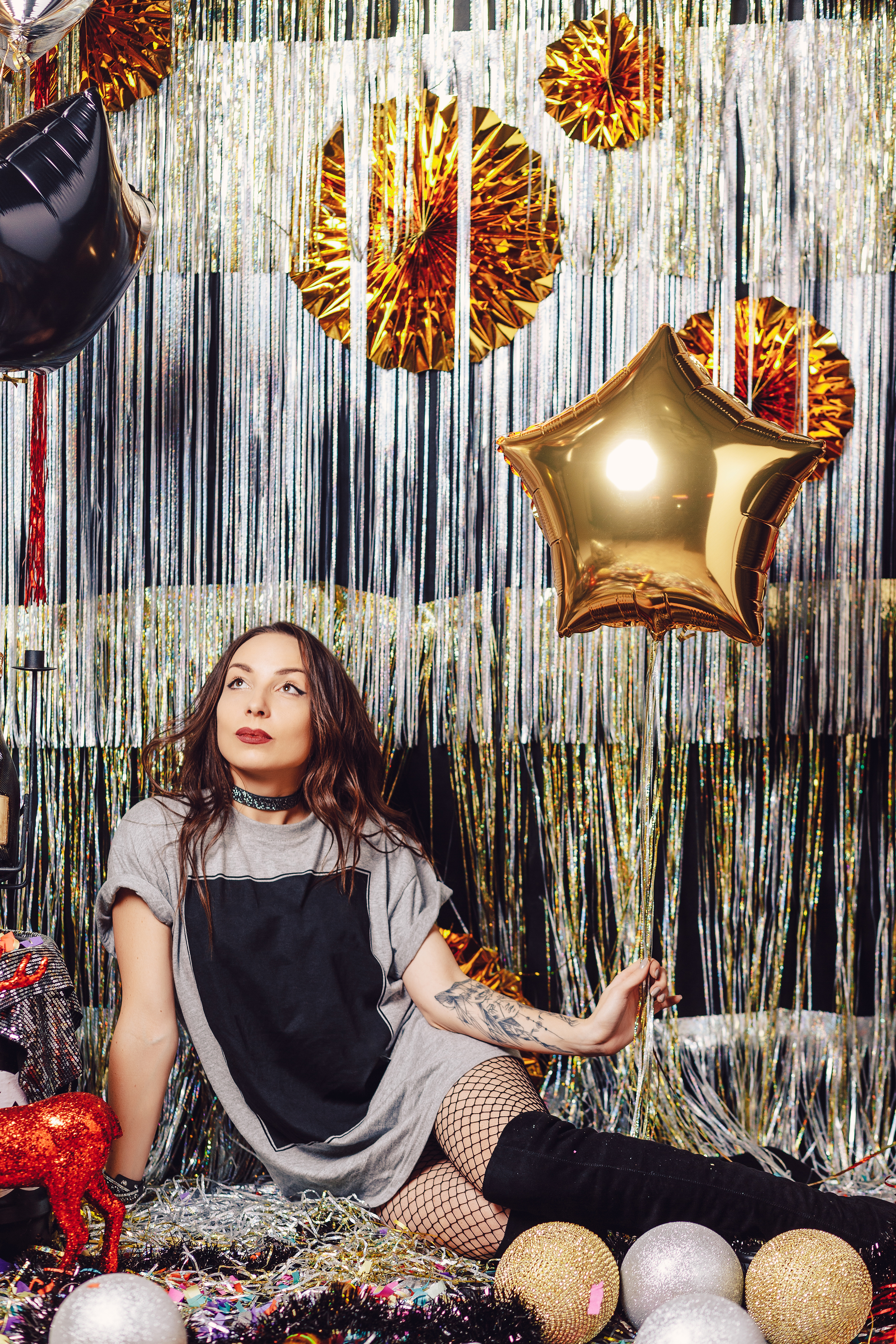 Adolescente sentada en un fondo de fiesta de cumpleaños con globos metálicos | Fuente: Freepik