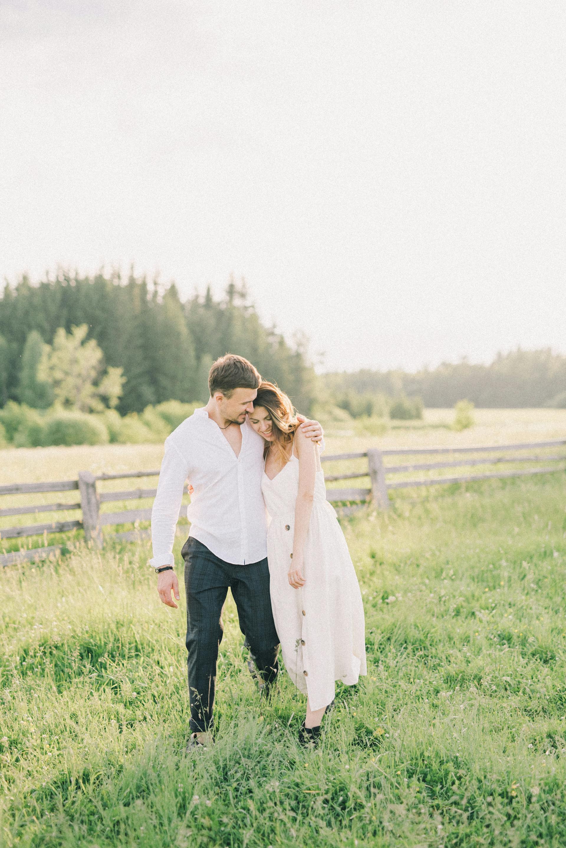 Una pareja feliz paseando por un campo | Fuente: Pexels