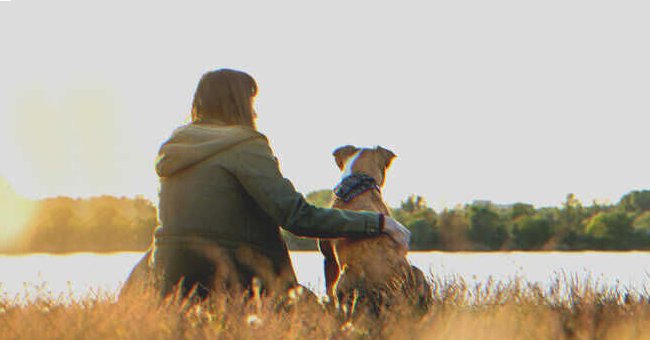 Una mujer con un perro frente a un lago | Foto. Shutterstock