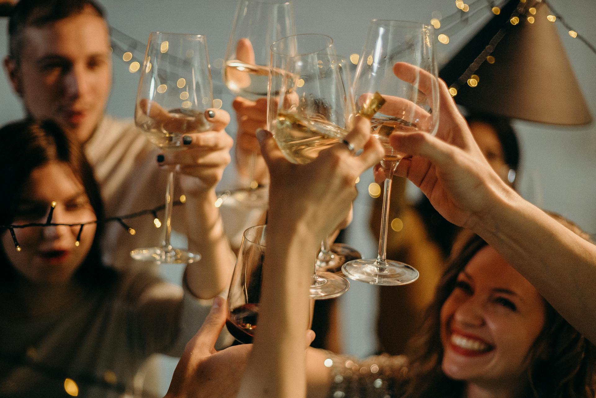 Amigos levantando sus copas en un brindis | Fuente: Pexels