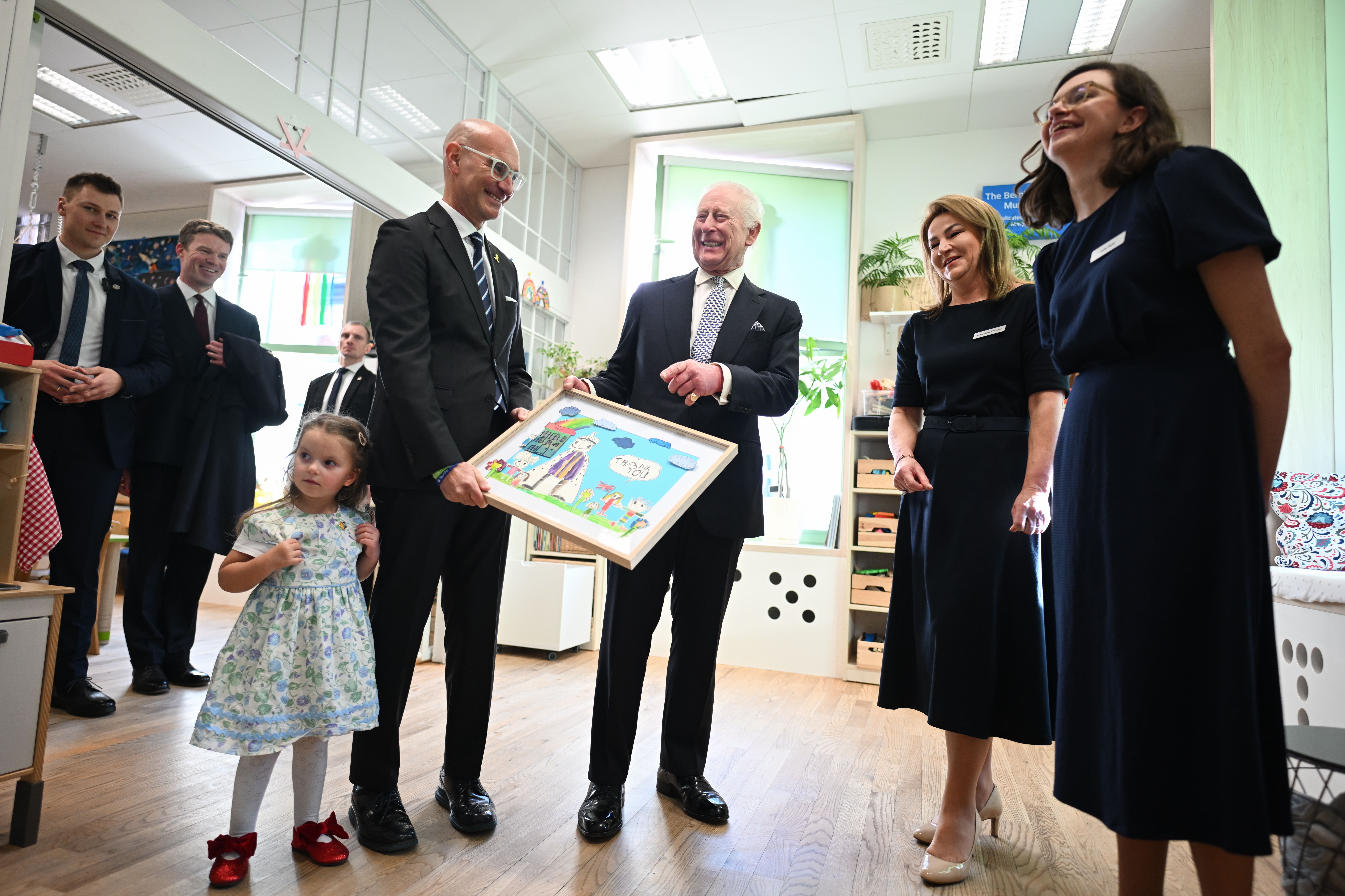 El rey Charles III recibe un cuadro de unos niños que le agradecen su visita al Centro Comunitario Judío de Cracovia, Polonia, el 27 de enero de 2025 | Fuente: Getty Images