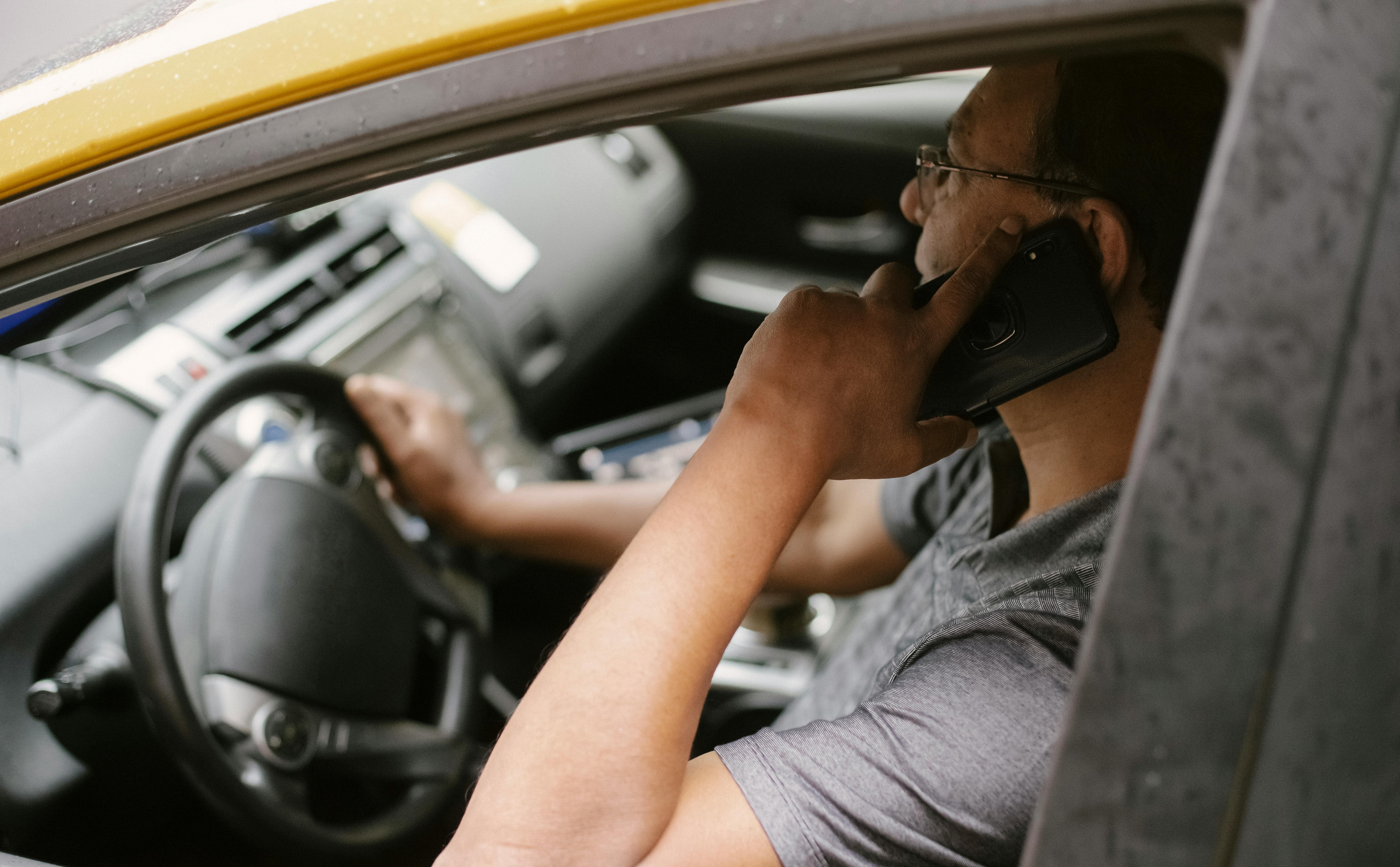 Hombre conduce mientras habla por teléfono | Foto: Pexels