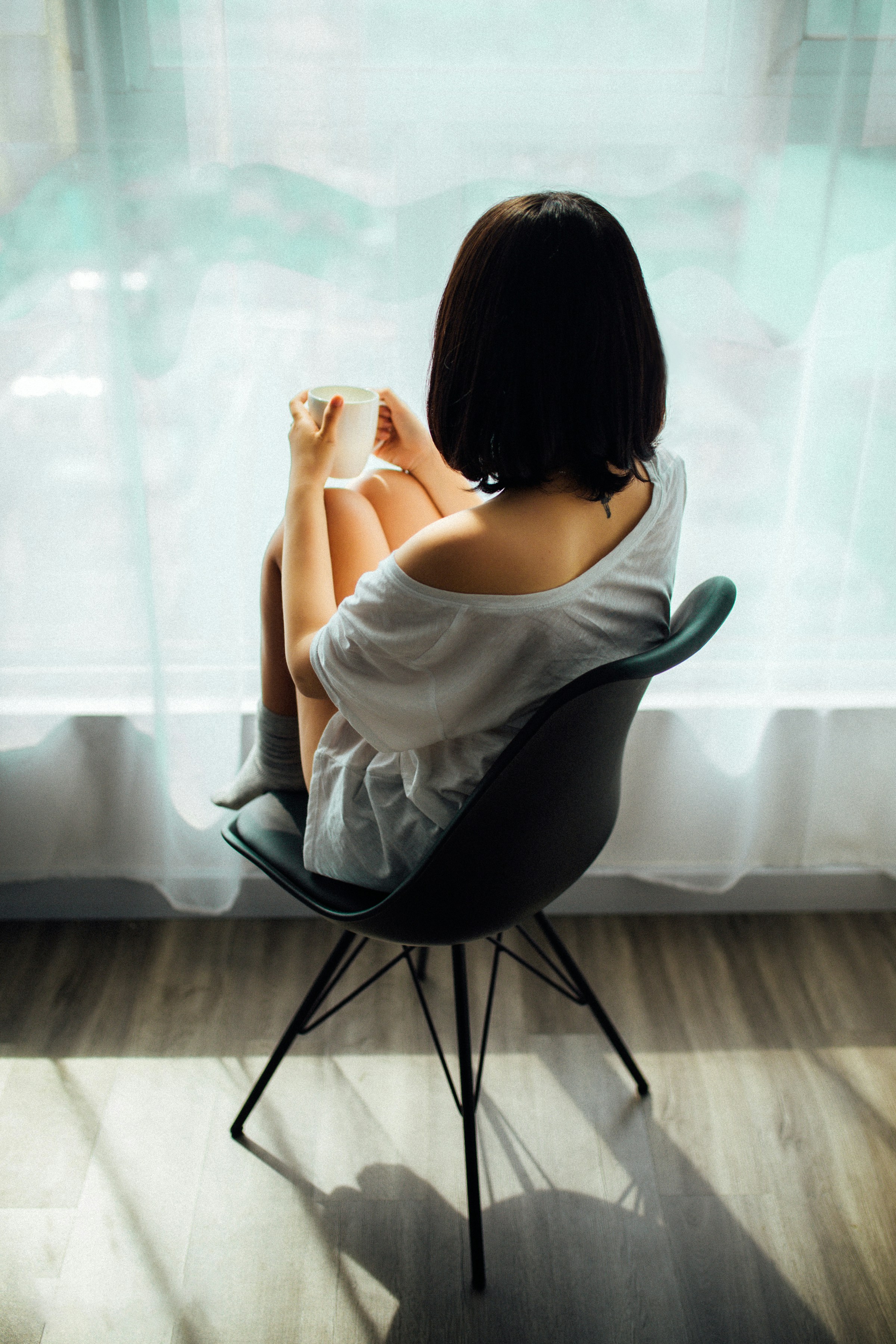 Una mujer sentada mirando por la ventana | Foto: Unsplash