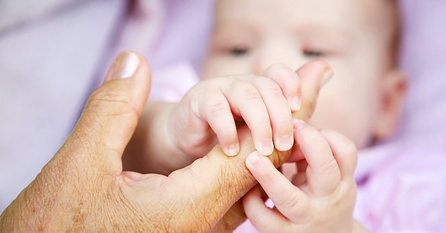 Bebé tomando la mano de un adulto. │ Foto: Shutterstock