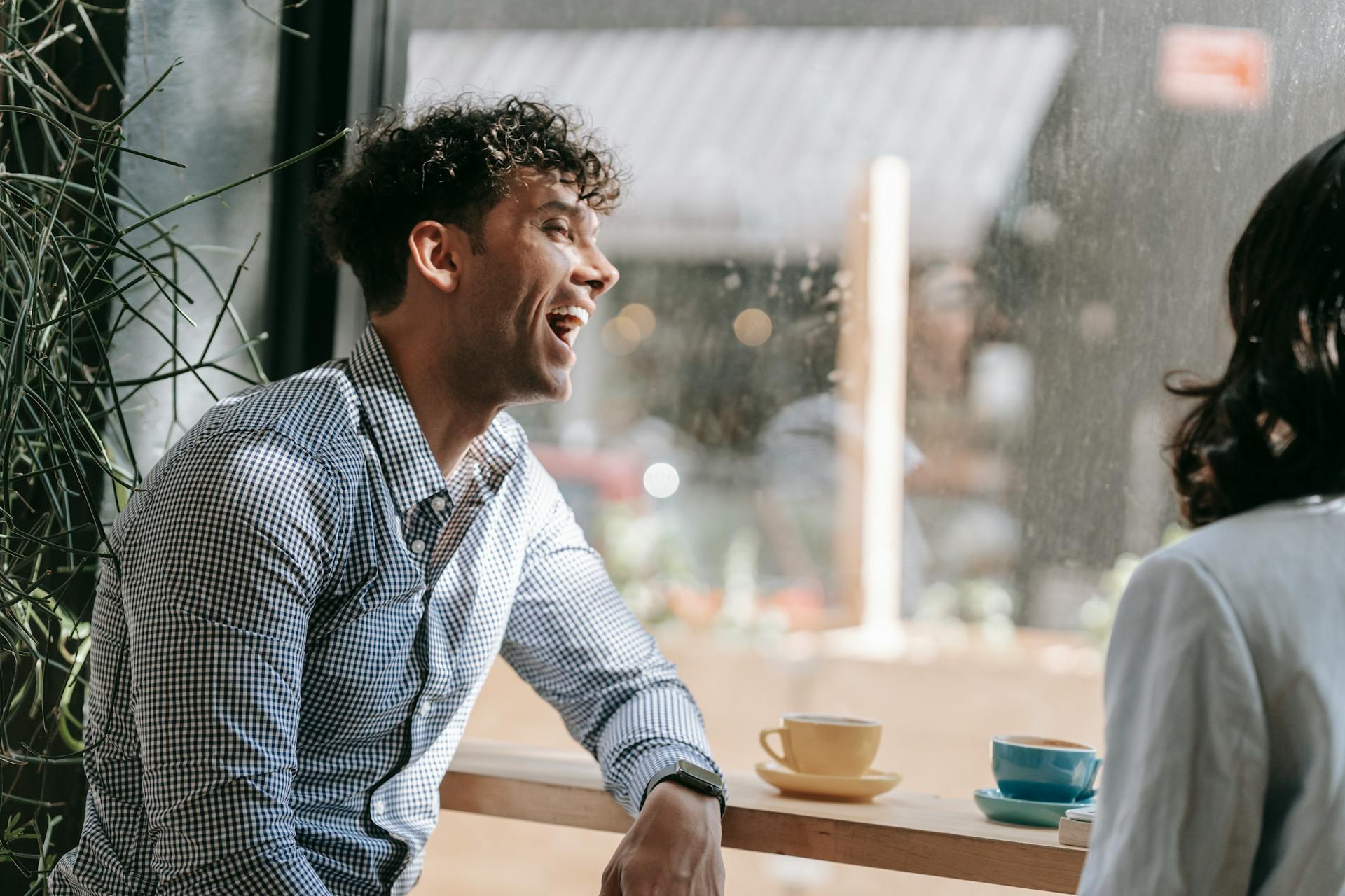 Un hombre riendo en una cafetería | Fuente: Pexels