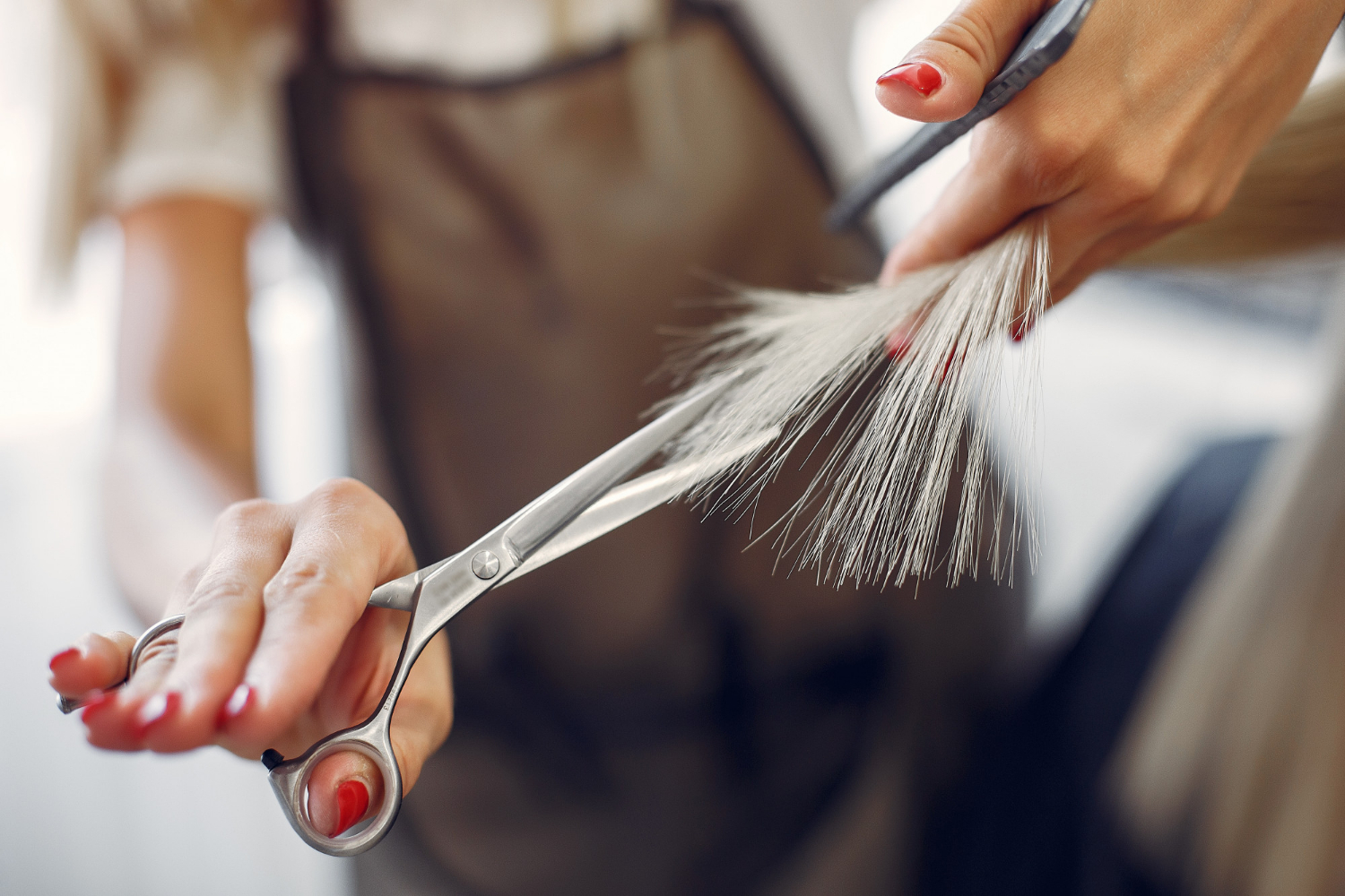 Recorte de una mujer cortando el pelo a alguien | Fuente: Freepik