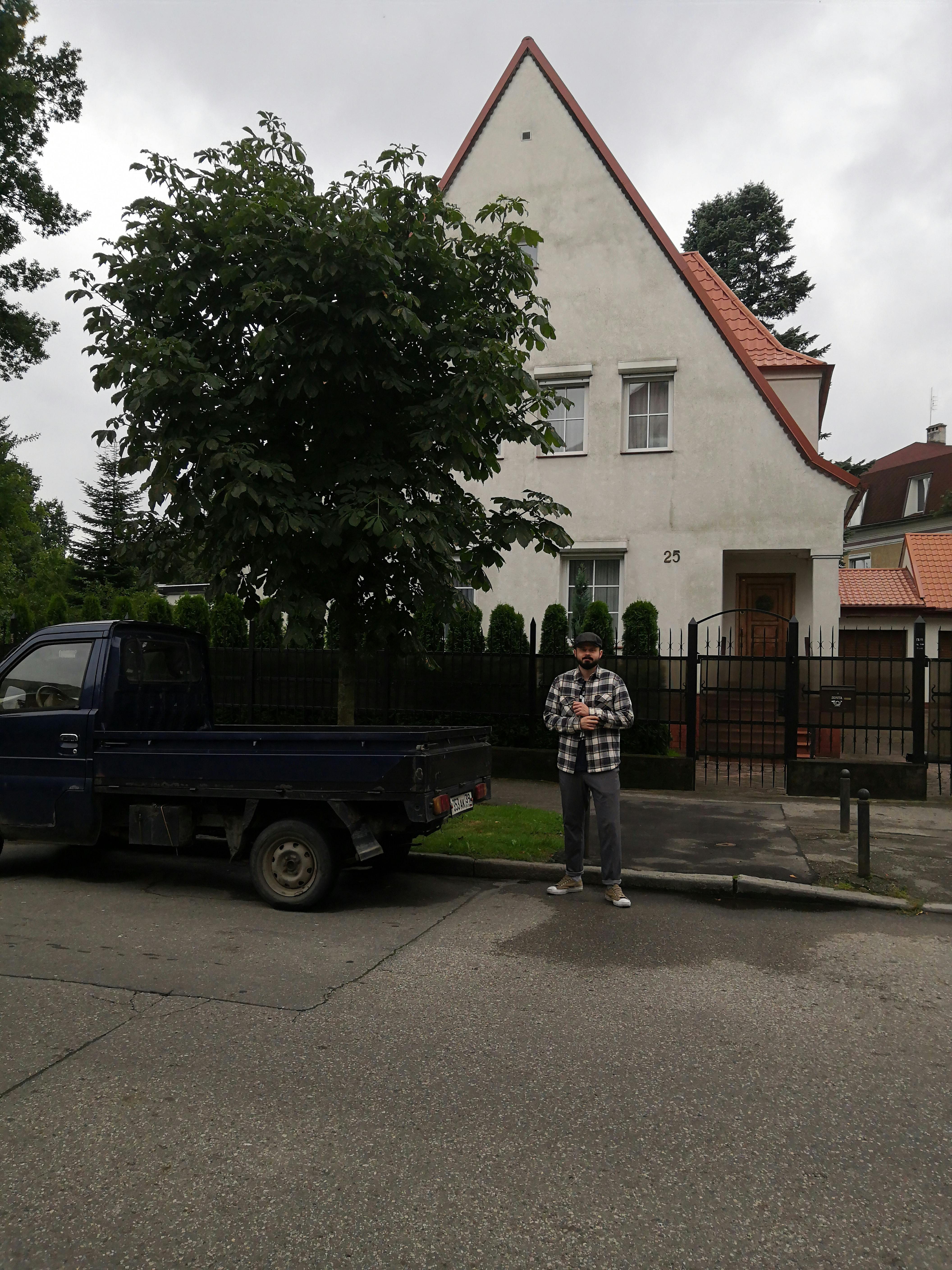 Hombre extraño junto a un automóvil cerca de una casa | Fuente: Pexels