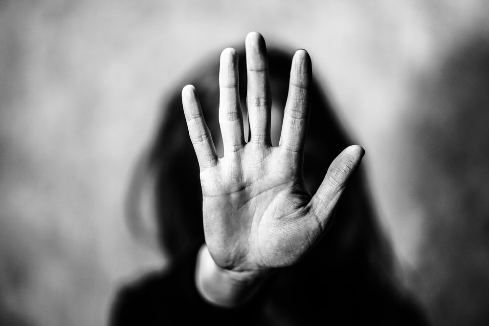 Una mujer alza la mano pidiéndole a alguien que se detenga. | Foto: Shutterstock