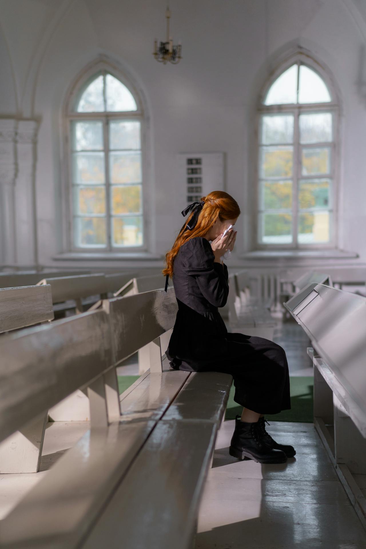 Una mujer solitaria y emotiva sentada en la iglesia y llorando | Fuente: Pexels