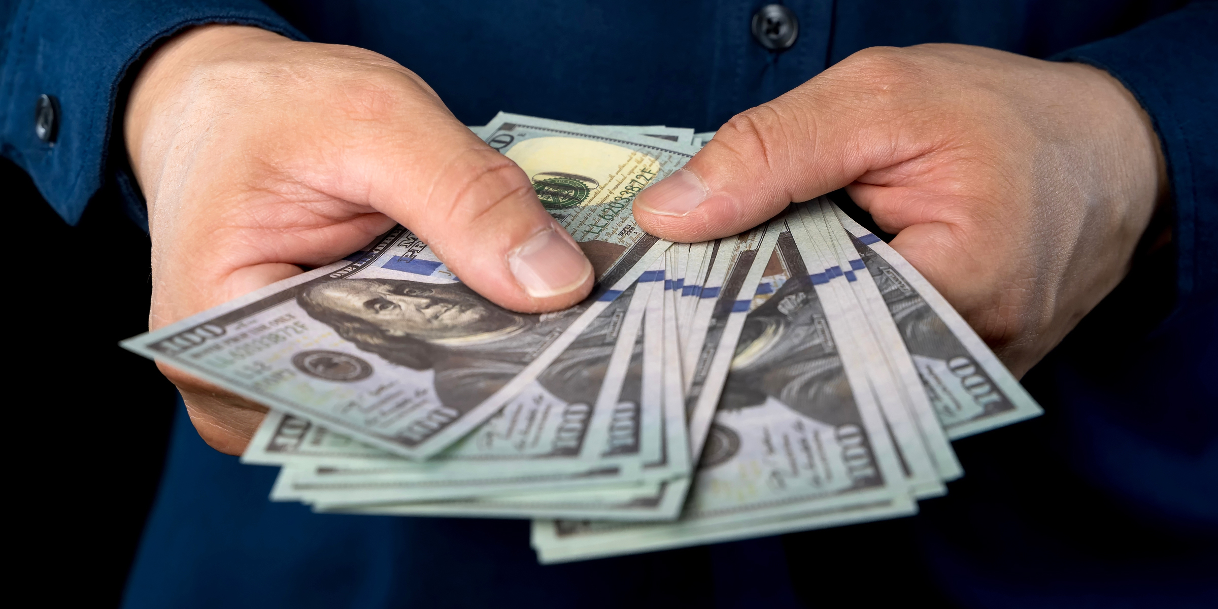 Billetes en las manos | Fuente: Shutterstock
