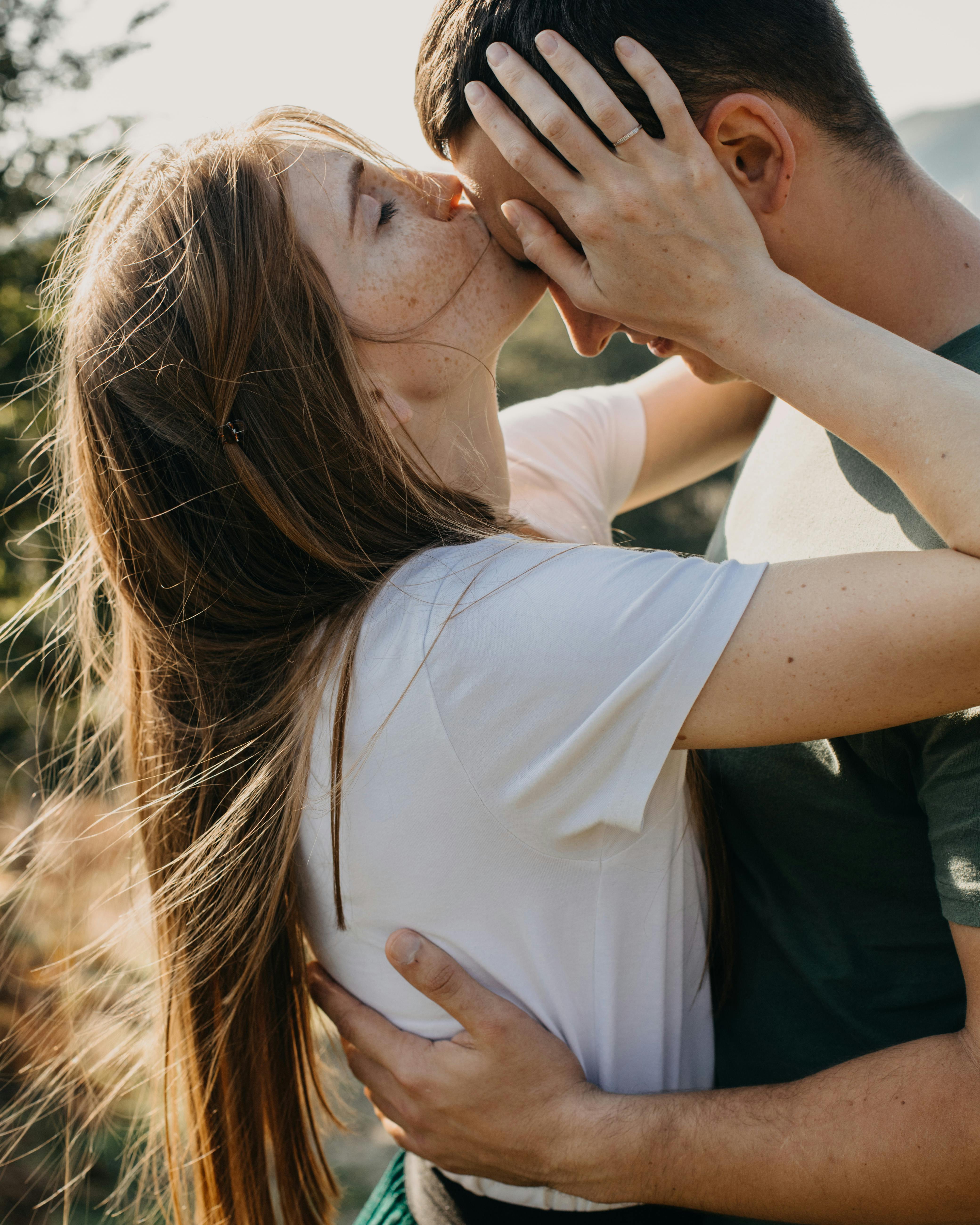Una mujer besa a su pareja en la frente | Foto: Pexels