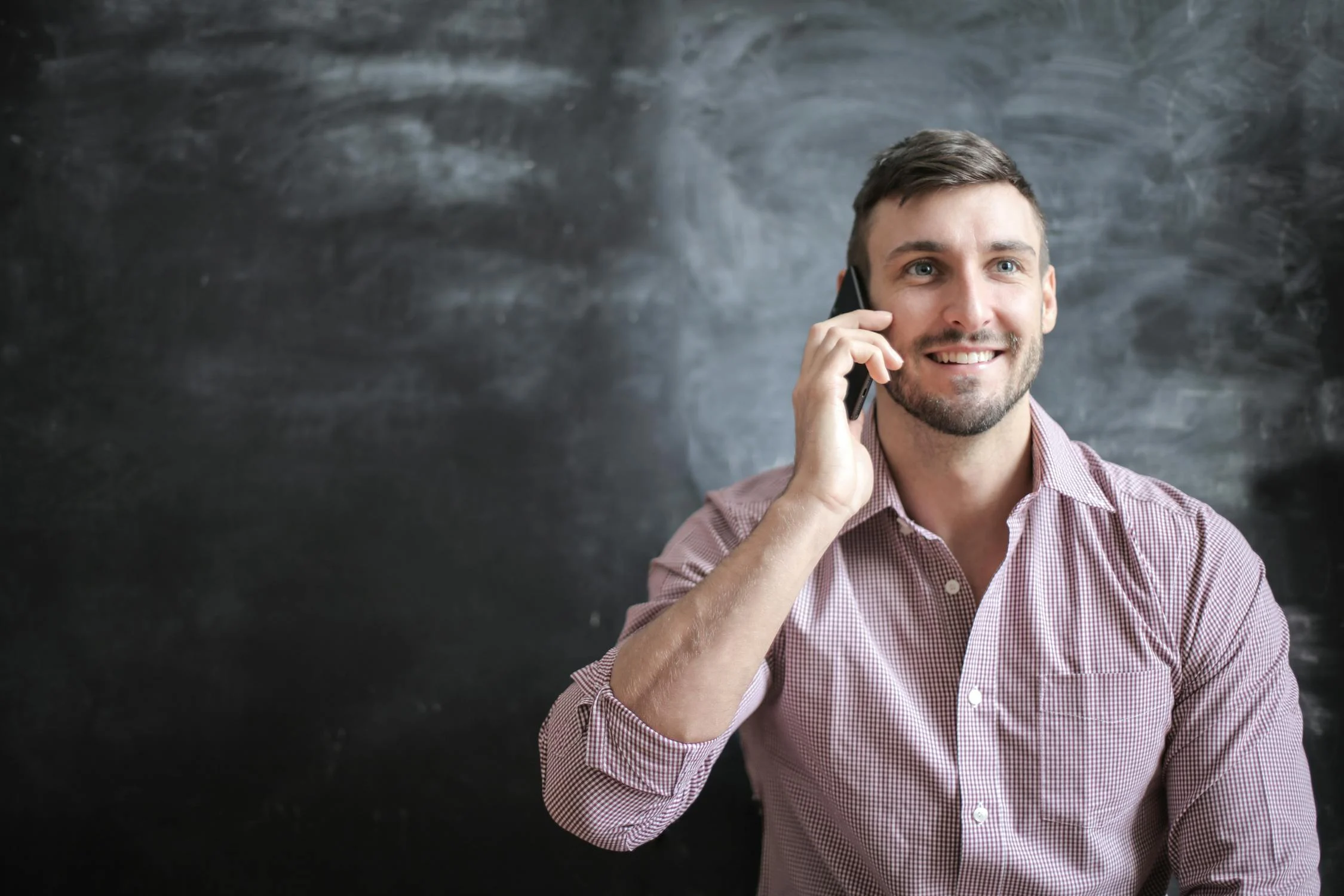 Un hombre sonriente hablando por teléfono | Fuente: Pexels