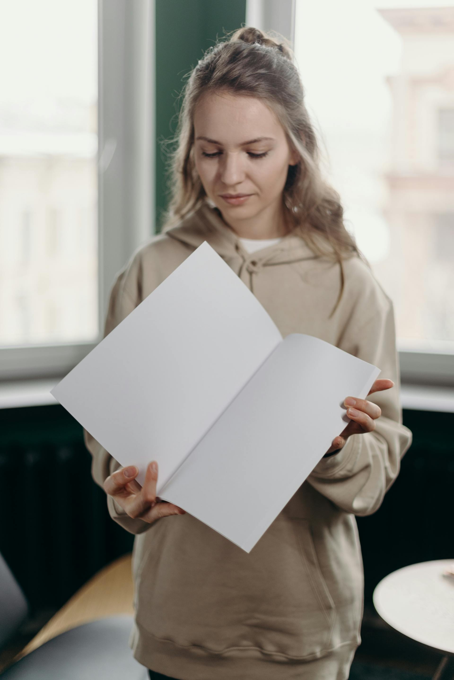 Mujer con un papel blanco en sus manos | Fuente: Pexels