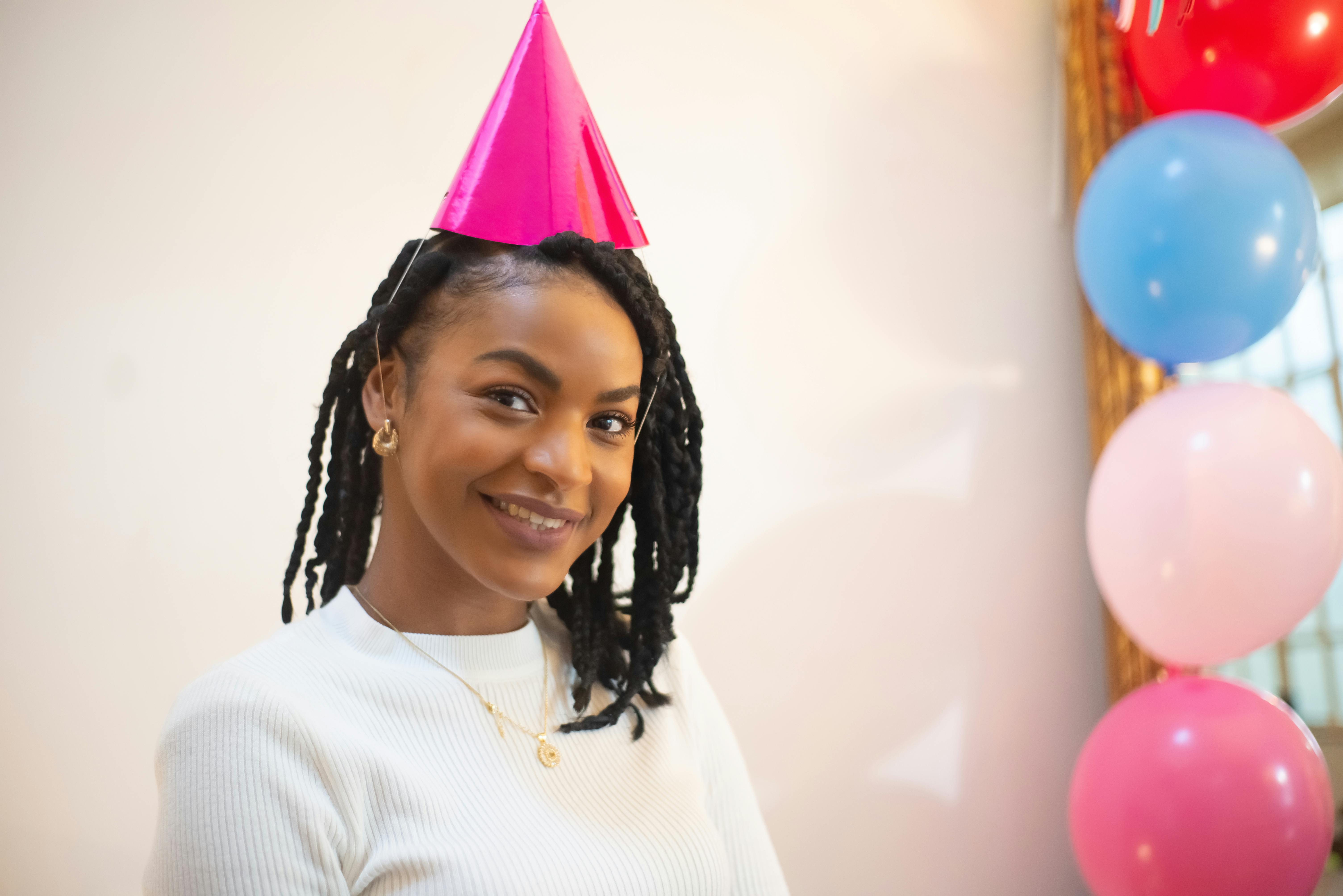 Una mujer feliz con un sombrero de fiesta | Fuente: Pexels