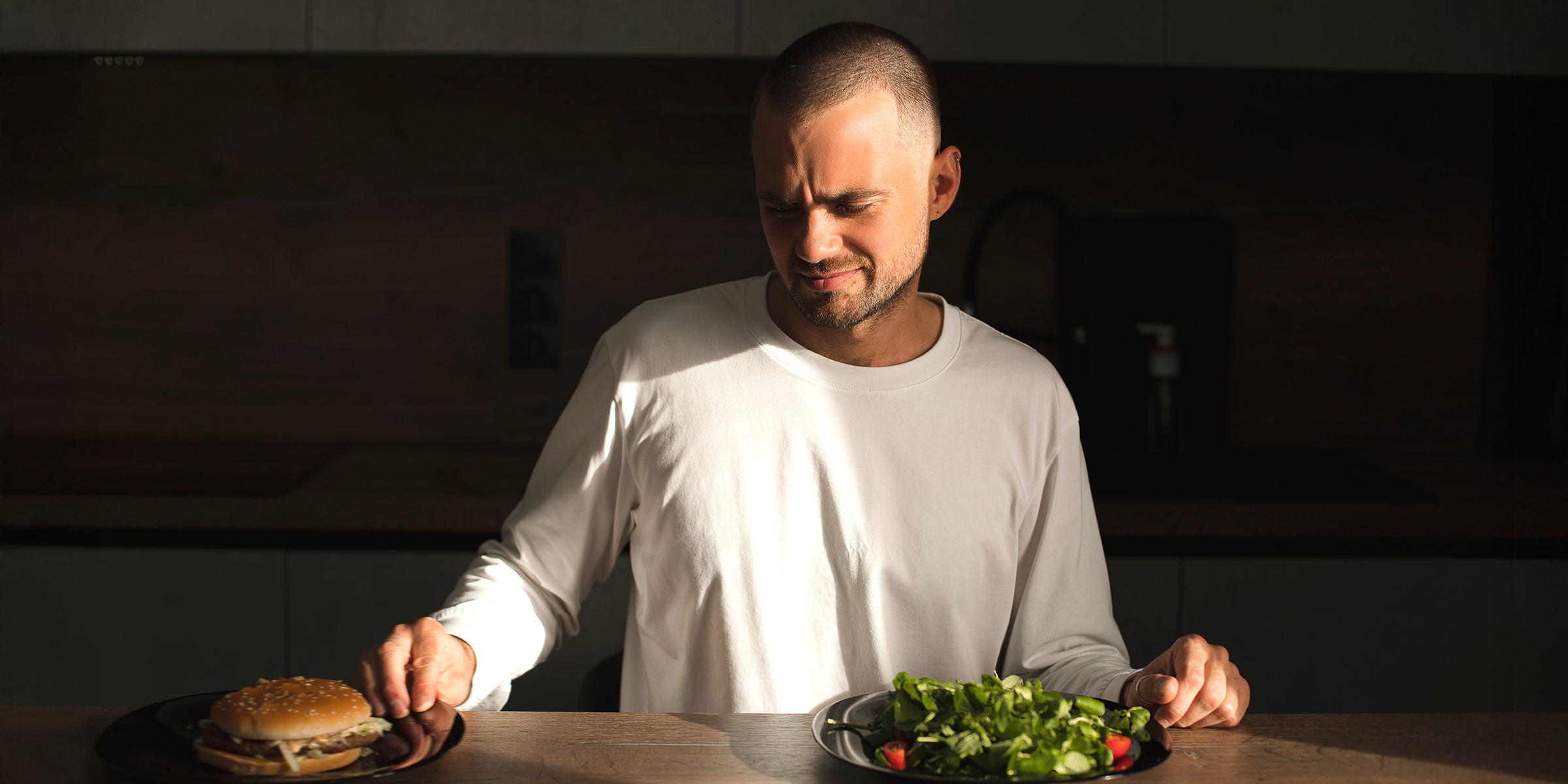Un hombre mirando un plato de hamburguesas | Fuente: Shutterstock