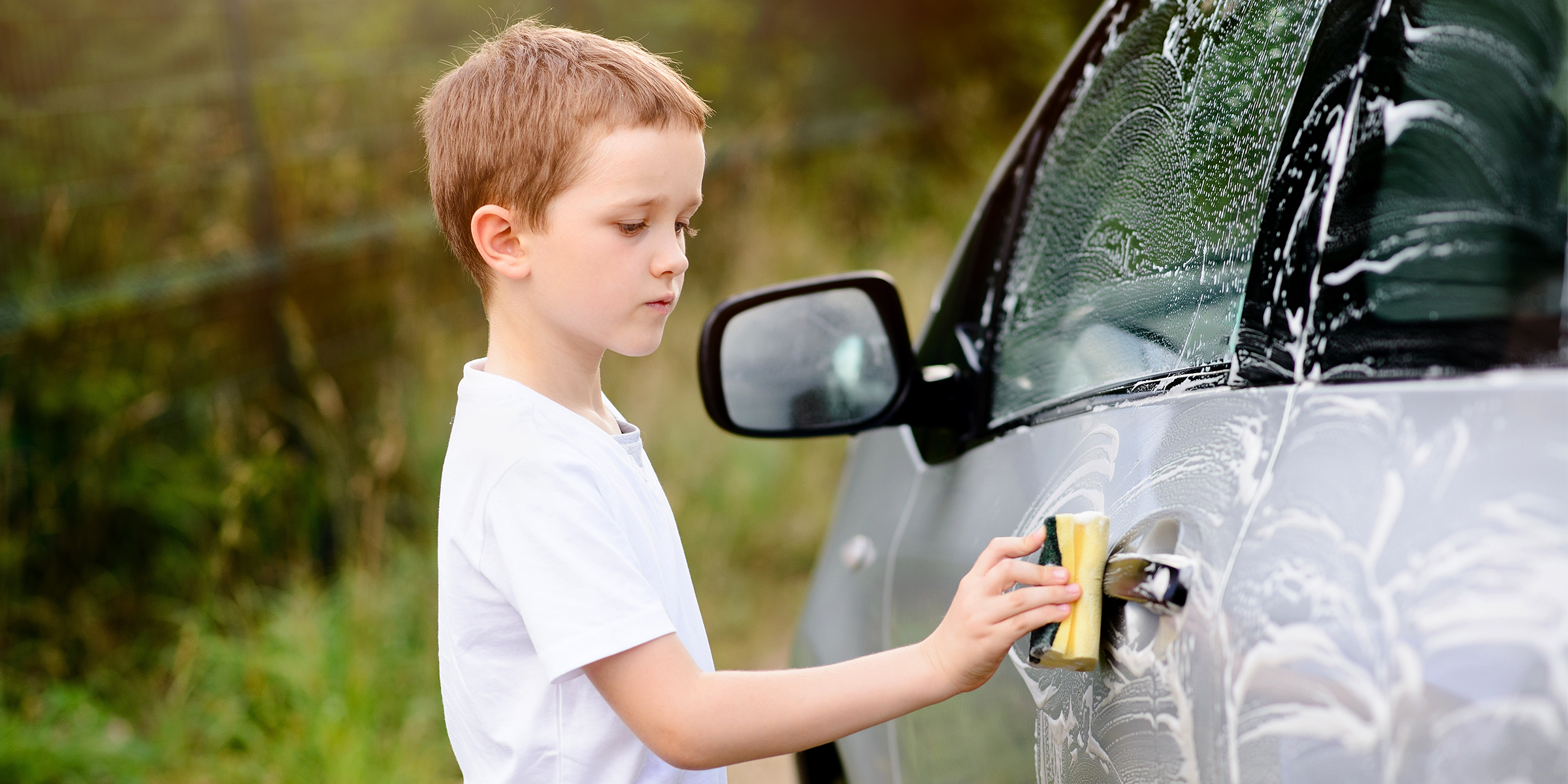 Un niño lavando un automóvil | Fuente: Shutterstock