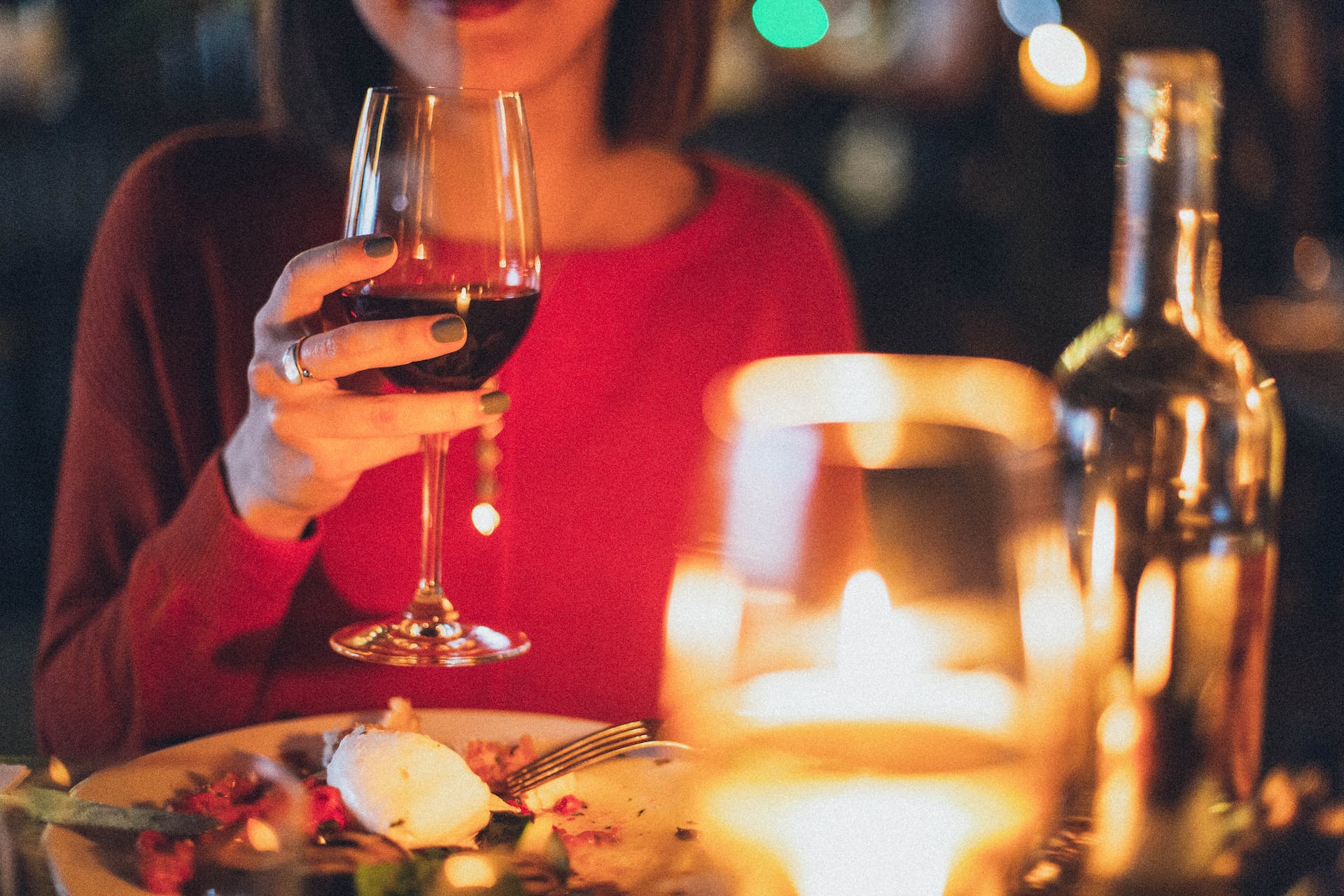 Una mujer con una copa de vino en la mano durante una cena en un restaurante | Fuente: Pexels