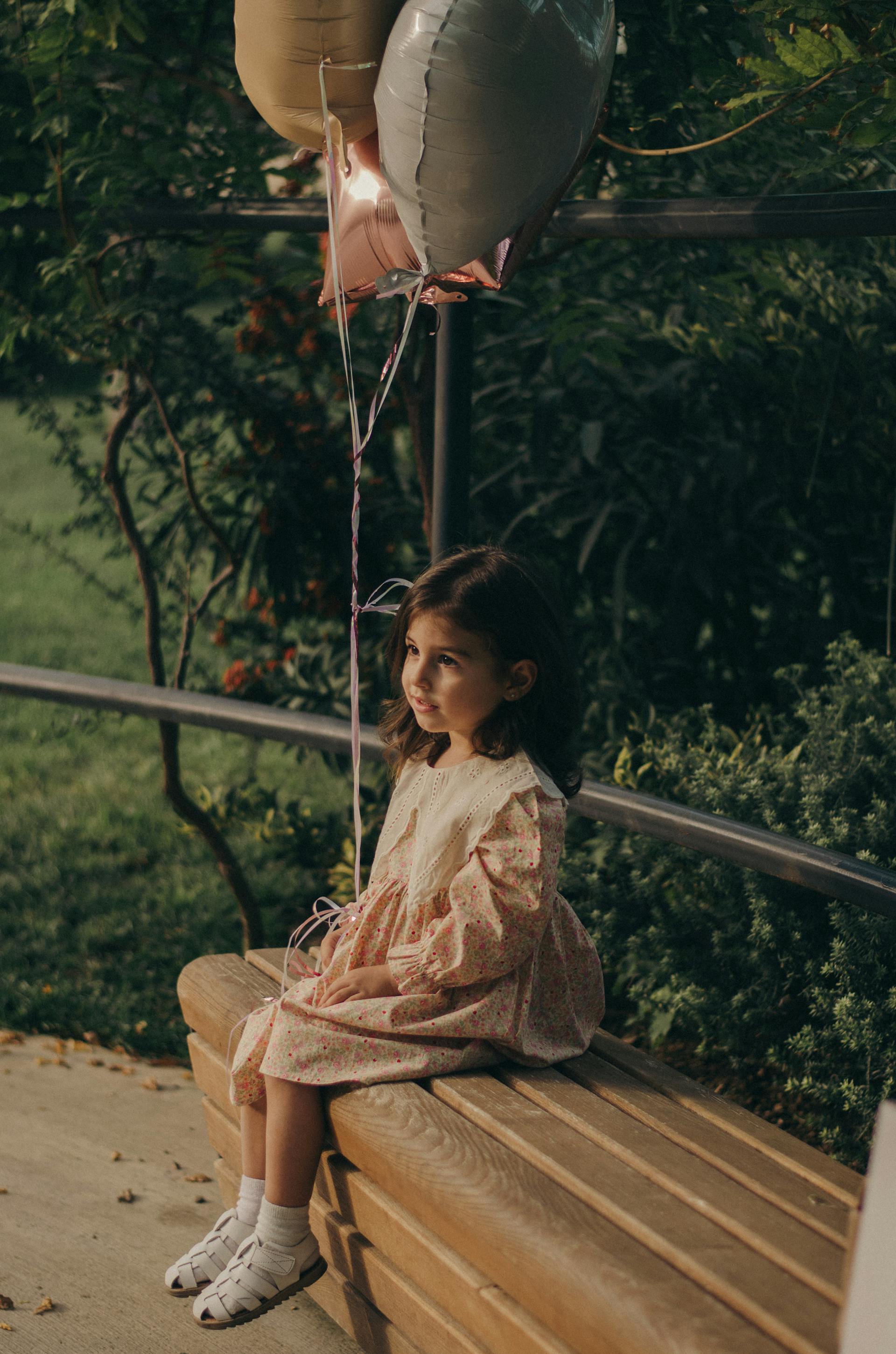 Una niña sentada en un banco del parque | Fuente: Pexels