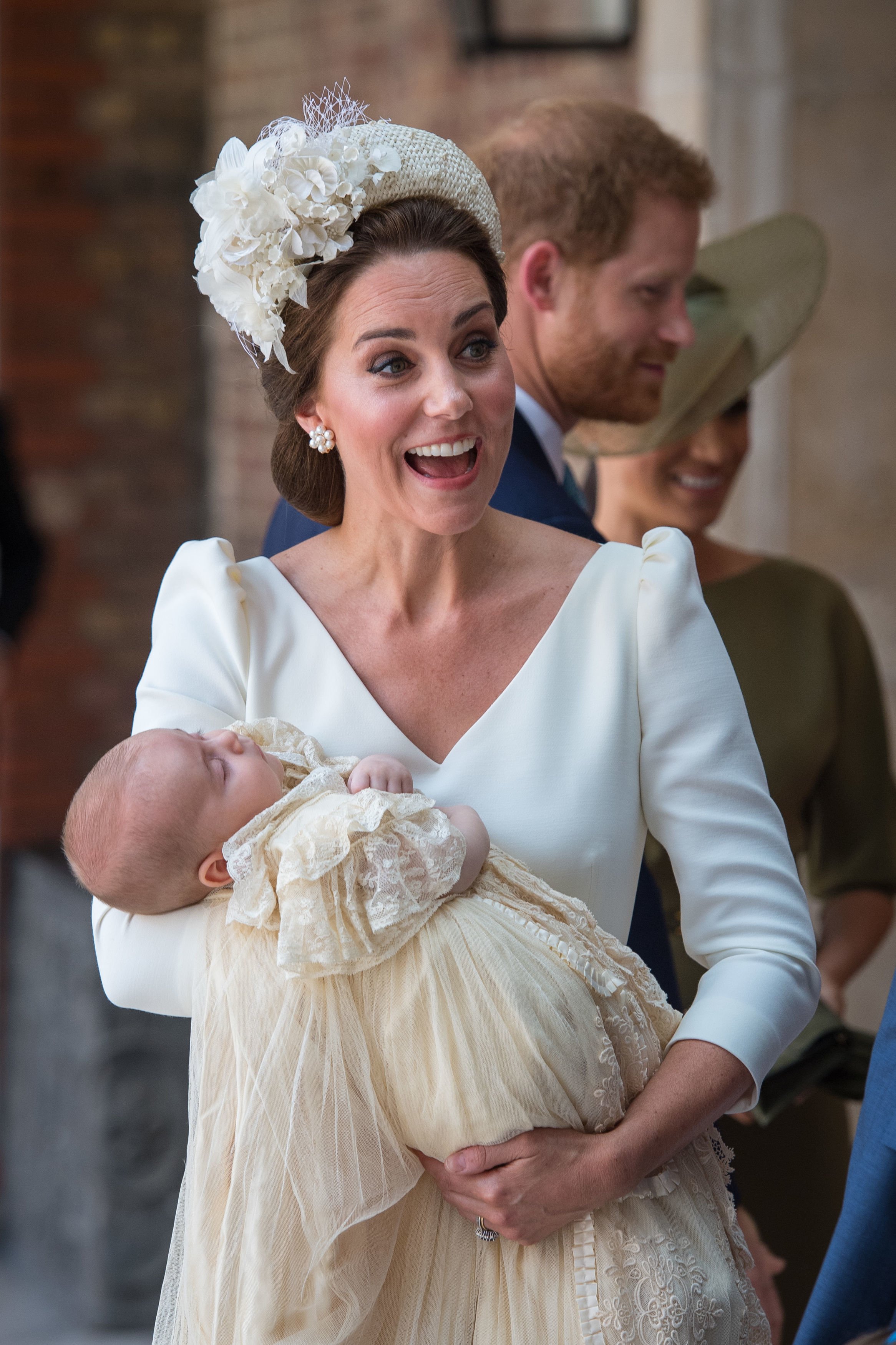 El príncipe Louis lleva la réplica del vestido de bautizo real mientras está siendo sostenido por Kate Middleton en el palacio de St. James en Londres, Inglaterra | Foto: Getty Images  