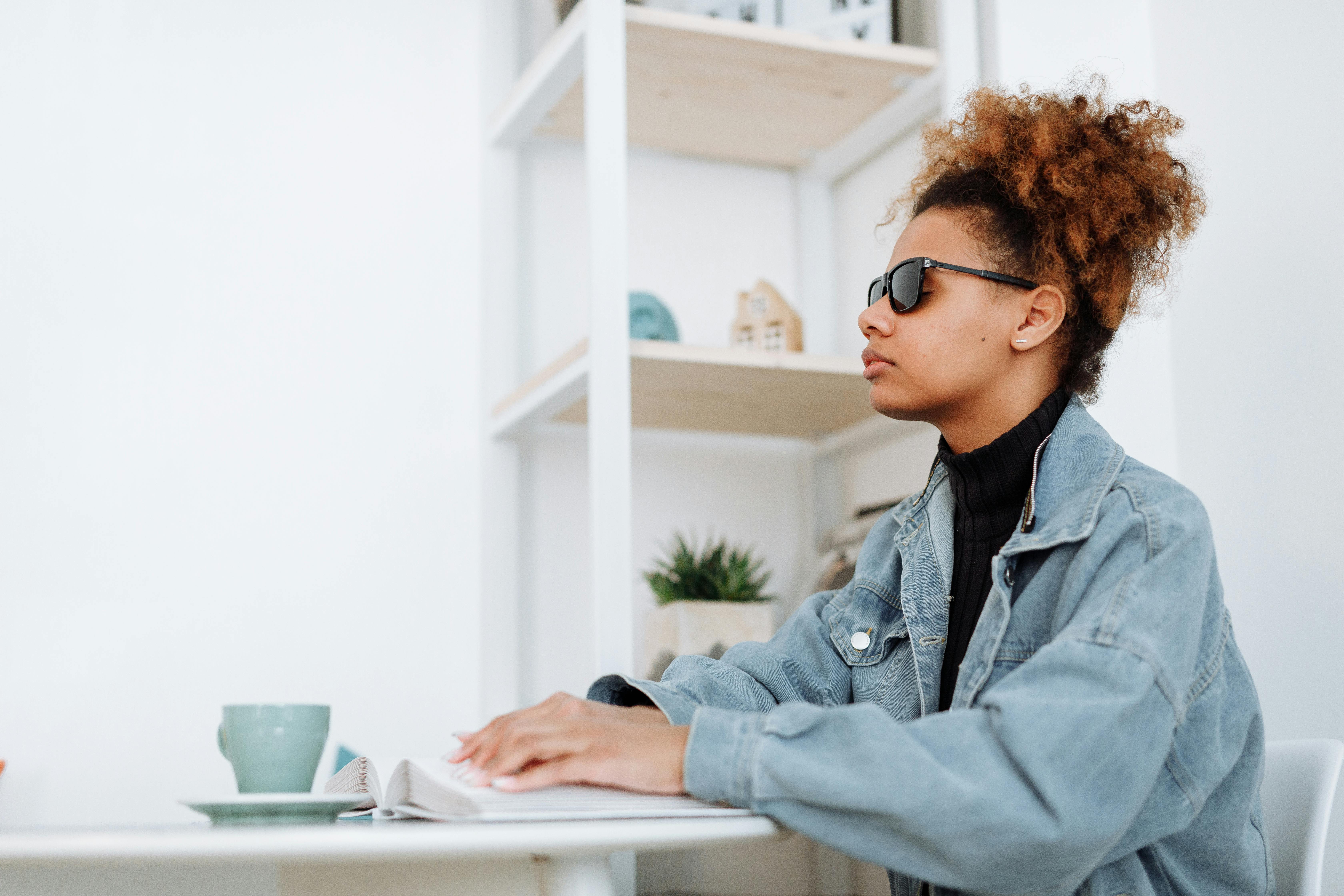 Mujer invidente sentada en un café | Foto: Pexels