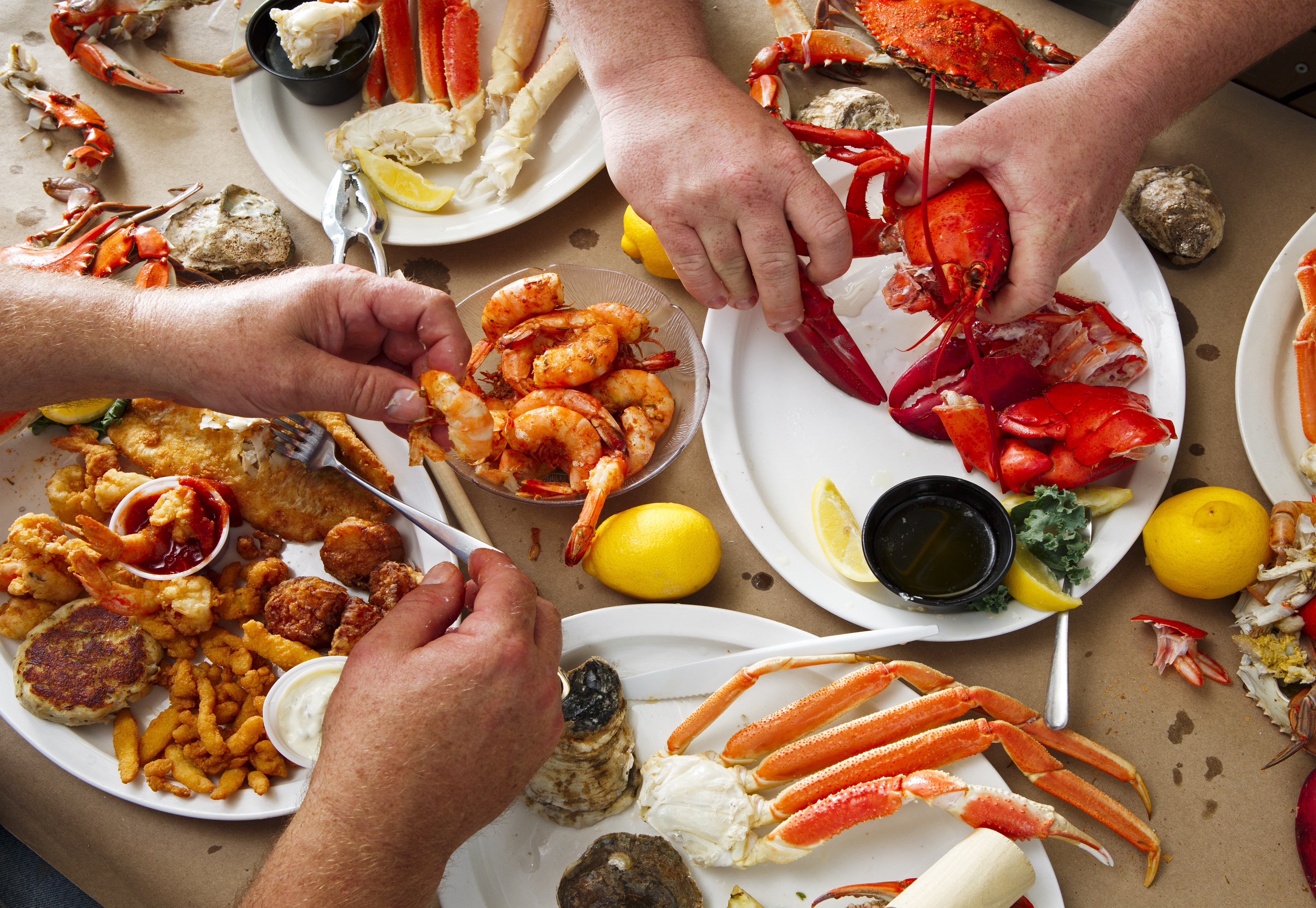 Personas cenando mariscos | Foto: Shutterstock