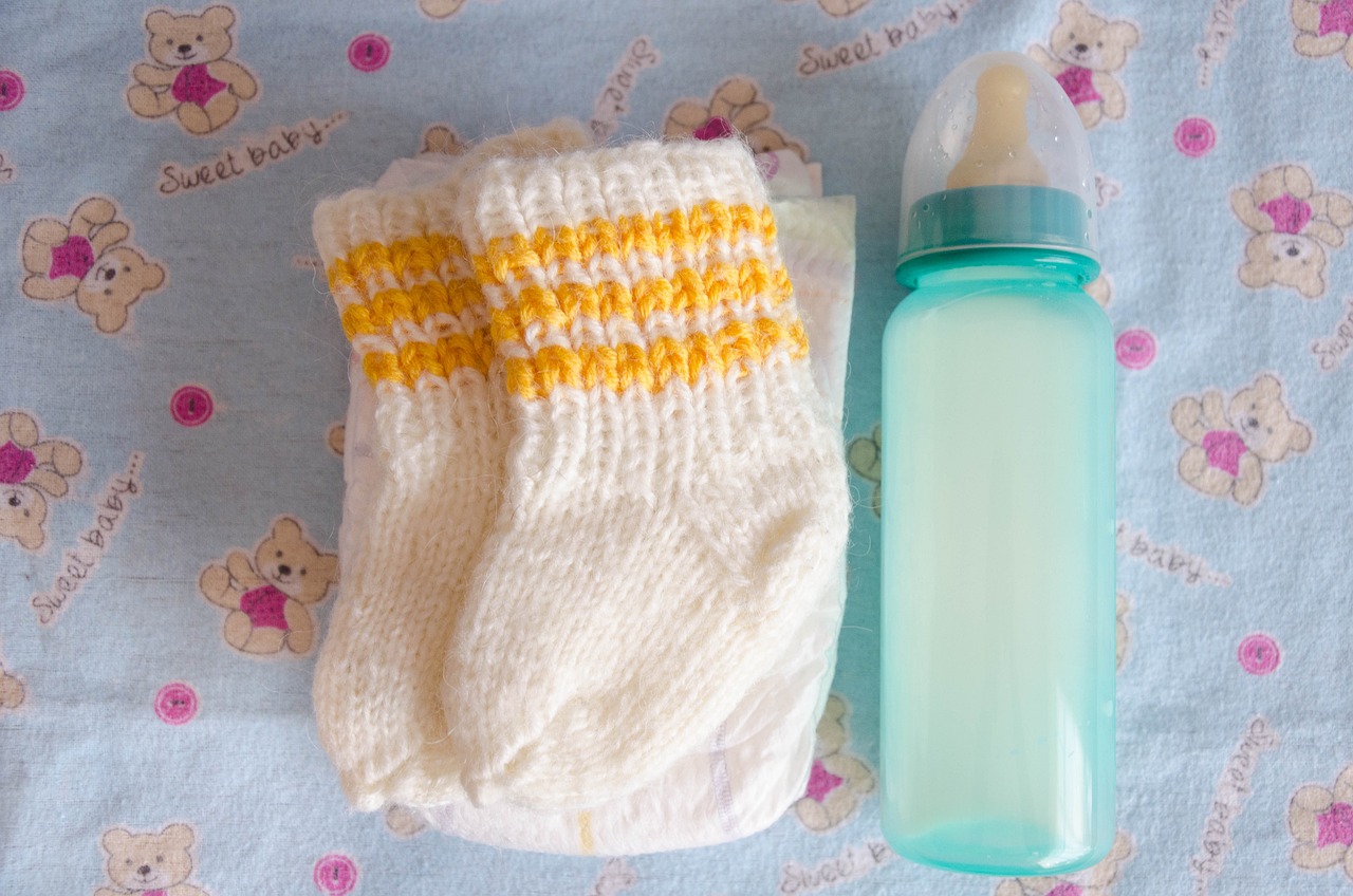 Medias de bebé y un biberón | Foto: Pixabay