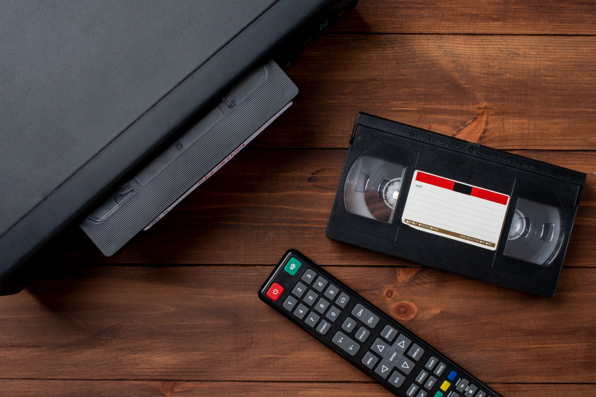 Un reproductor VHS con una cinta y un mando a distancia | Fuente: Freepik