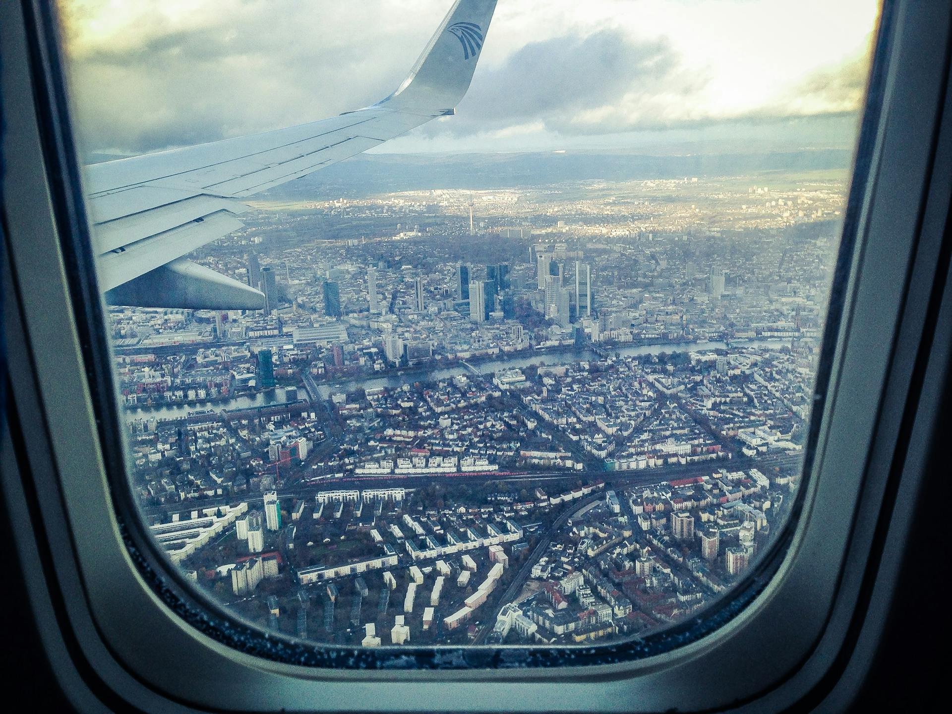Una ventana de avión mostrando edificios de la ciudad | Fuente: Pexels