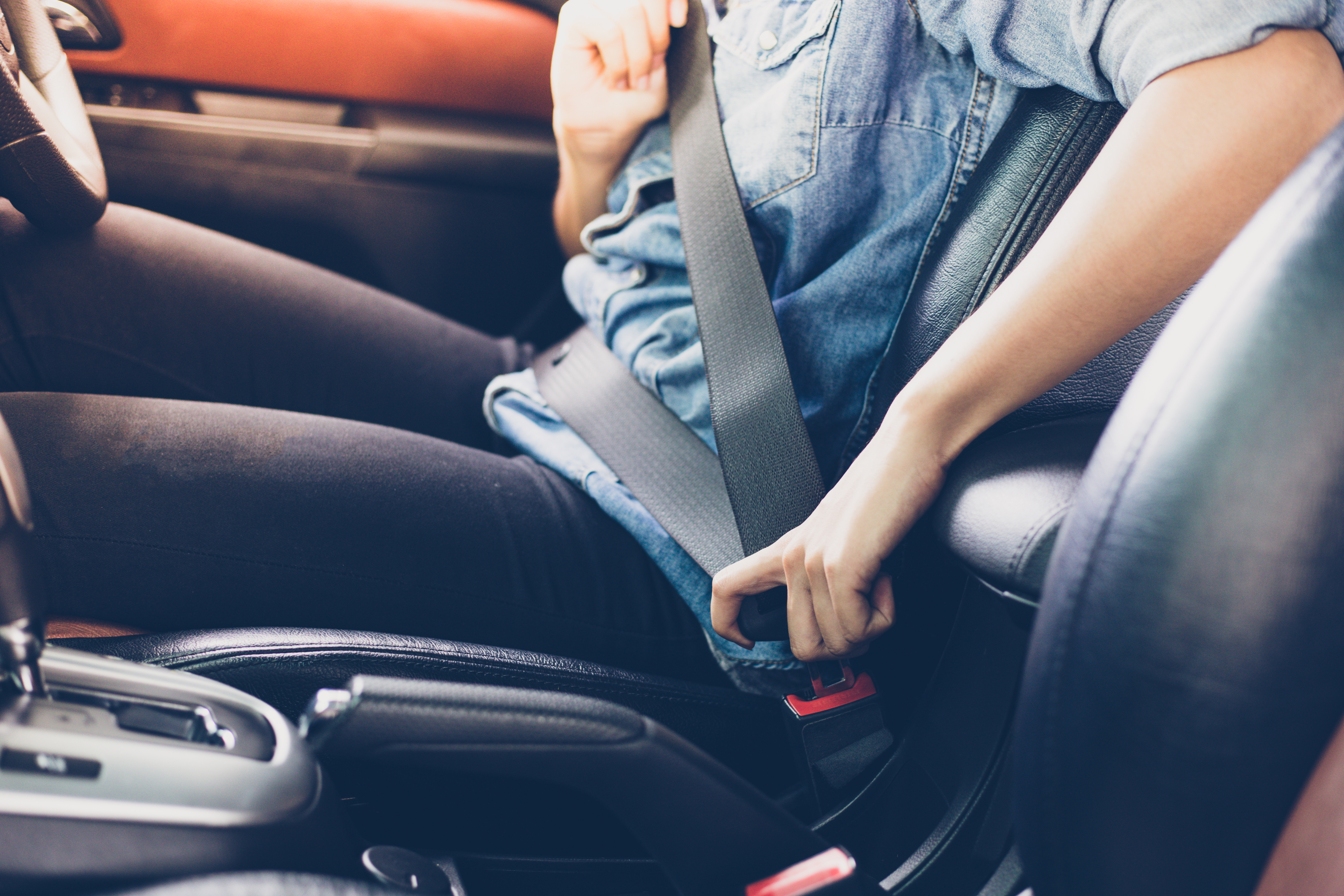 Mujer desabrochándose el cinturón de seguridad en el Automóvil. | Fuente: Shutterstock