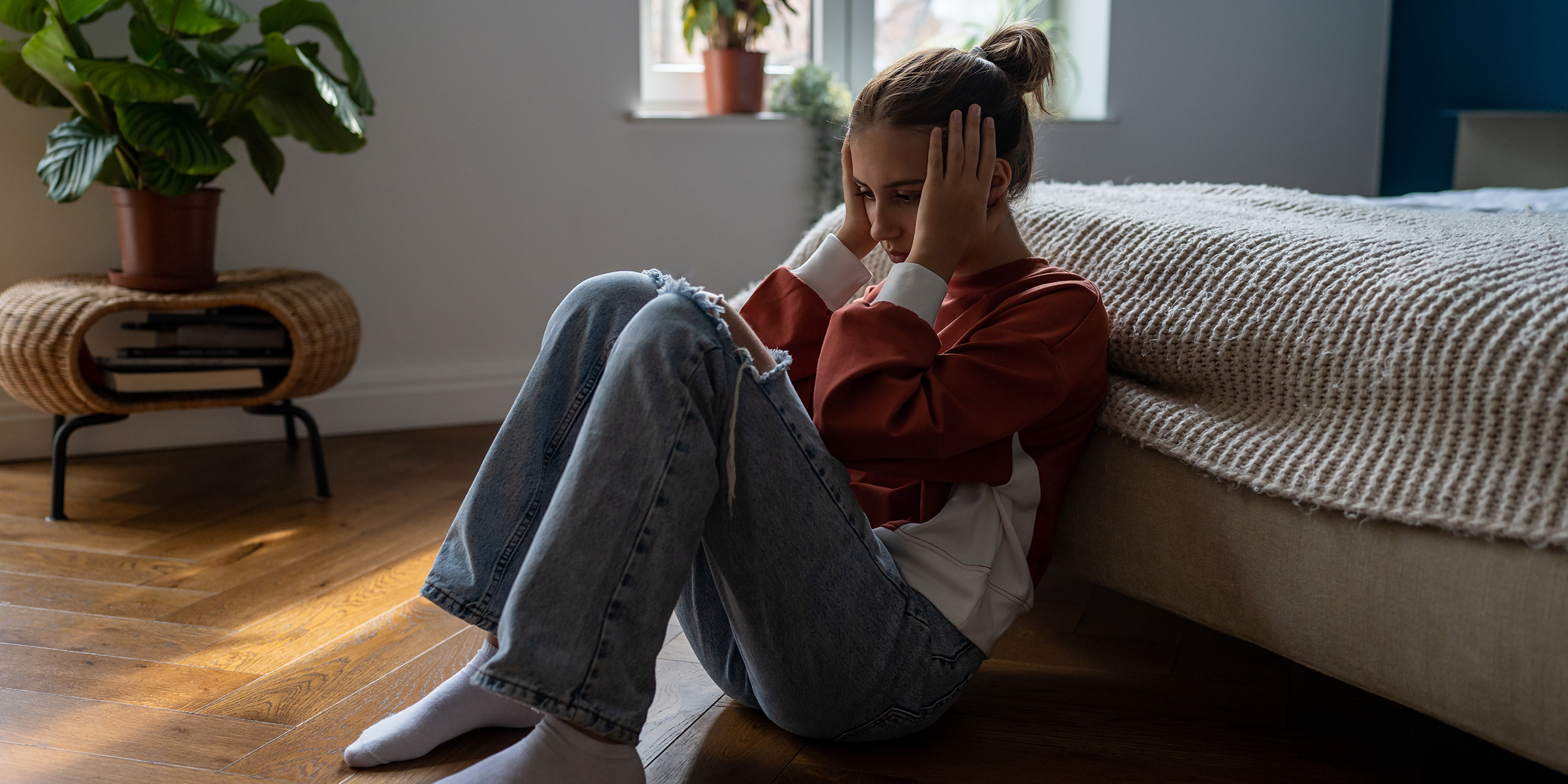 Una adolescente angustiada sentada en el suelo | Fuente: Shutterstock