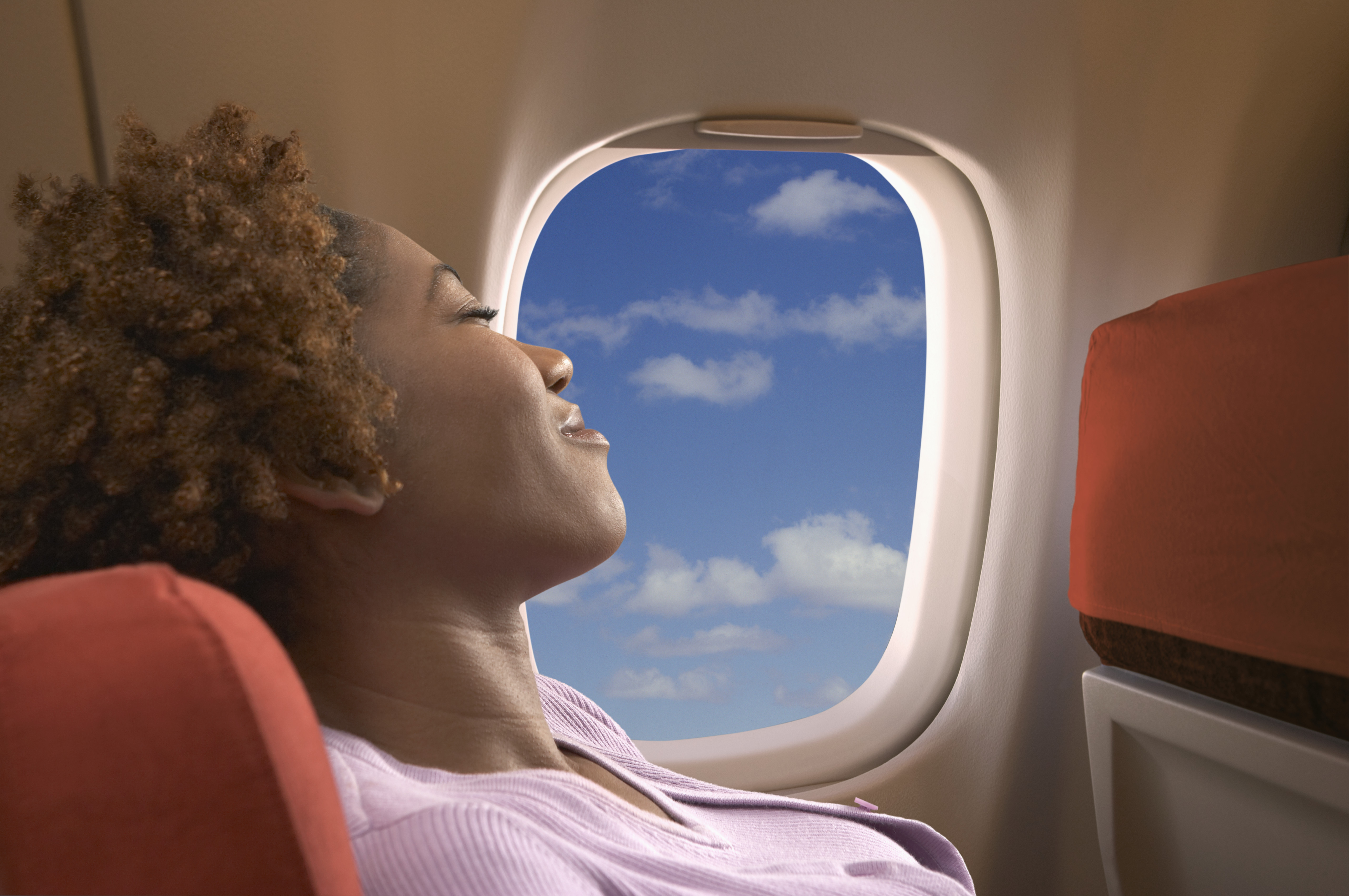 Una mujer relajándose en un avión | Foto: Getty Images