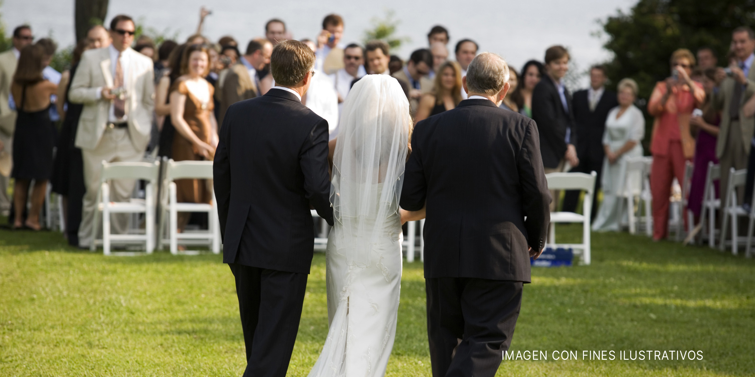 Novia caminando hacia el altar con dos hombres | Foto: Getty Images