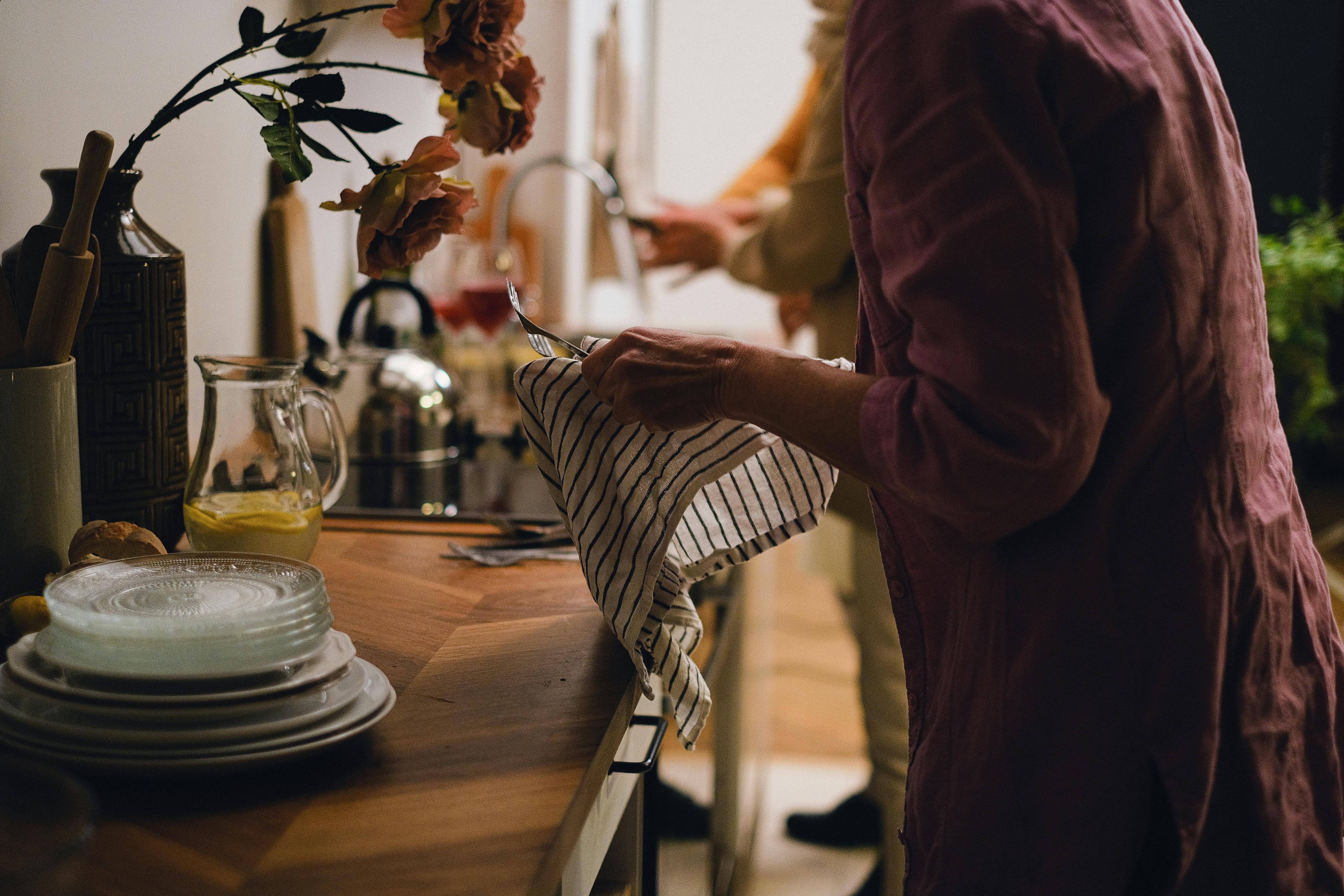 Una mujer secando los platos en el fregadero | Fuente: Pexels