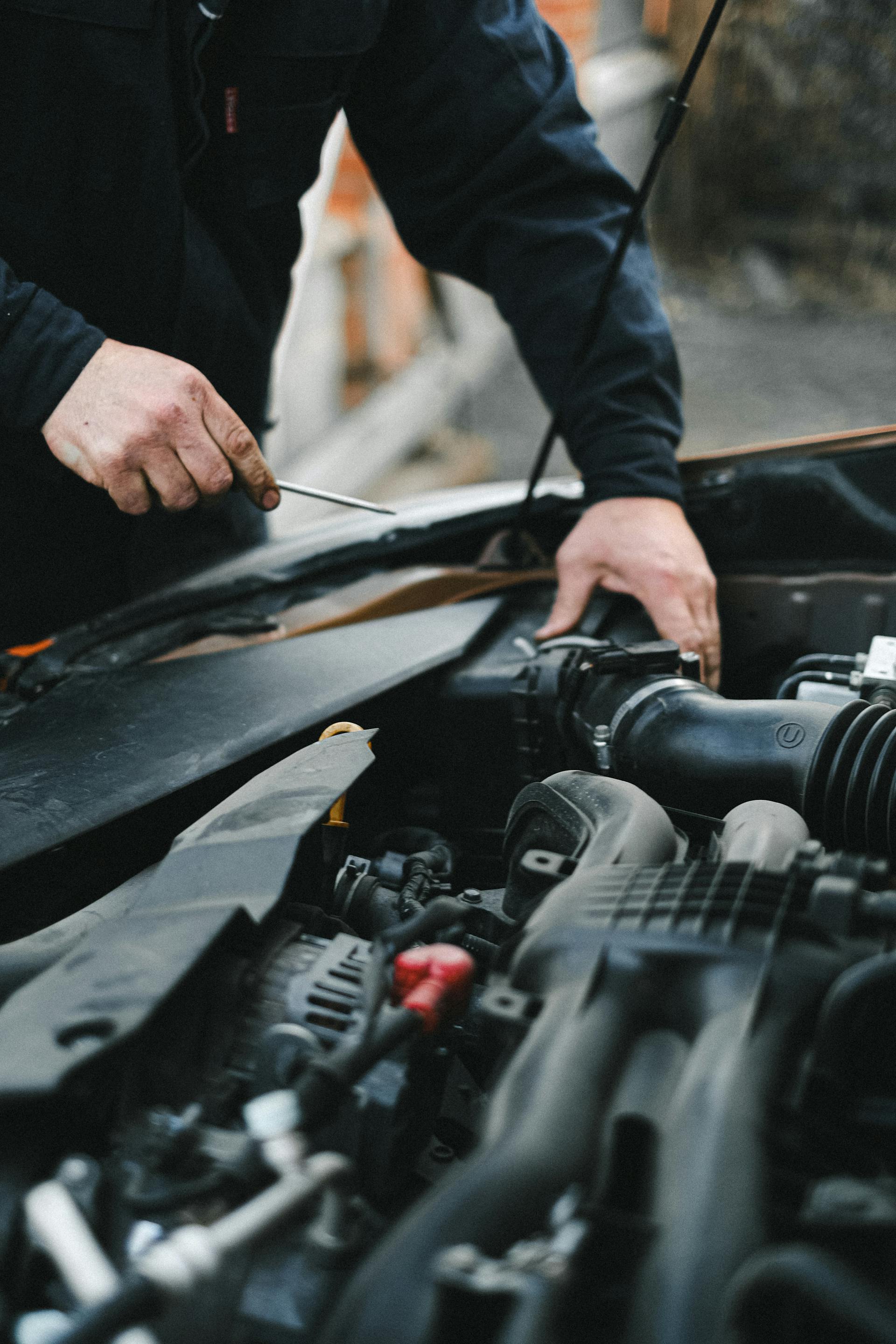 Un hombre trabajando en el motor de un Automóvil | Fuente: Pexels