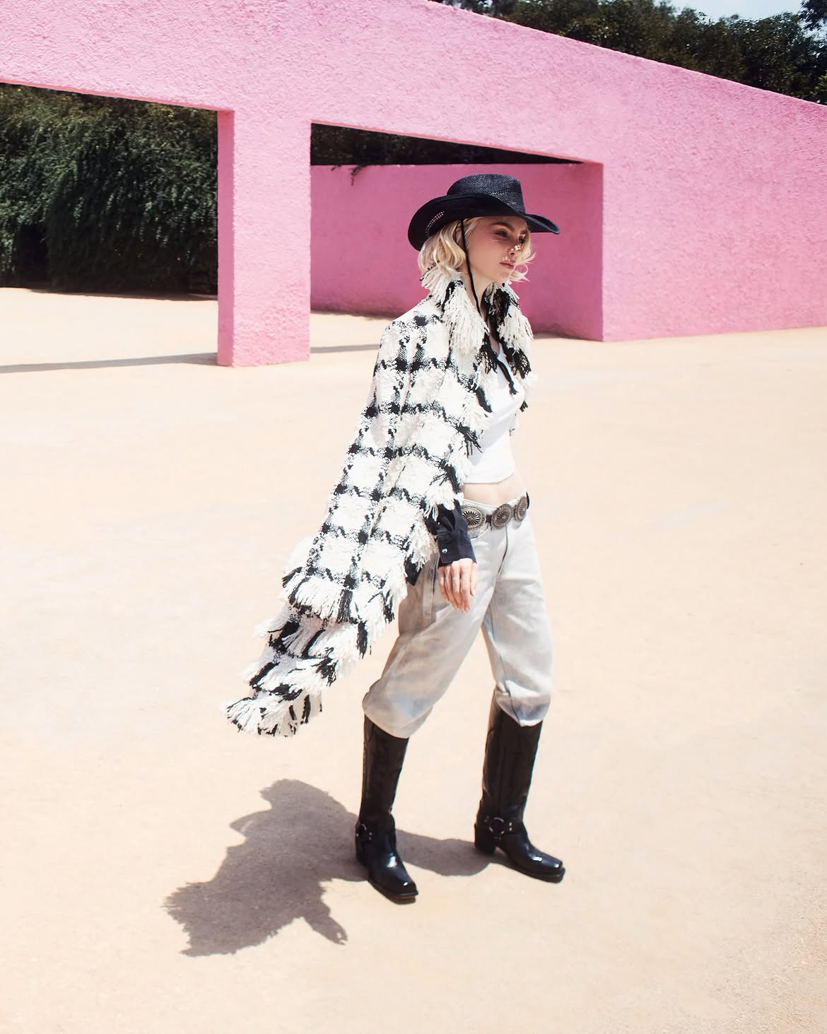 Belinda posando en su sesión de fotos para la revista Vogue con un look estilo vaquero con sombrero y un chal blanco con negro y pantalon de mezclilla gris claro | Fuente: Instagram/belindapop