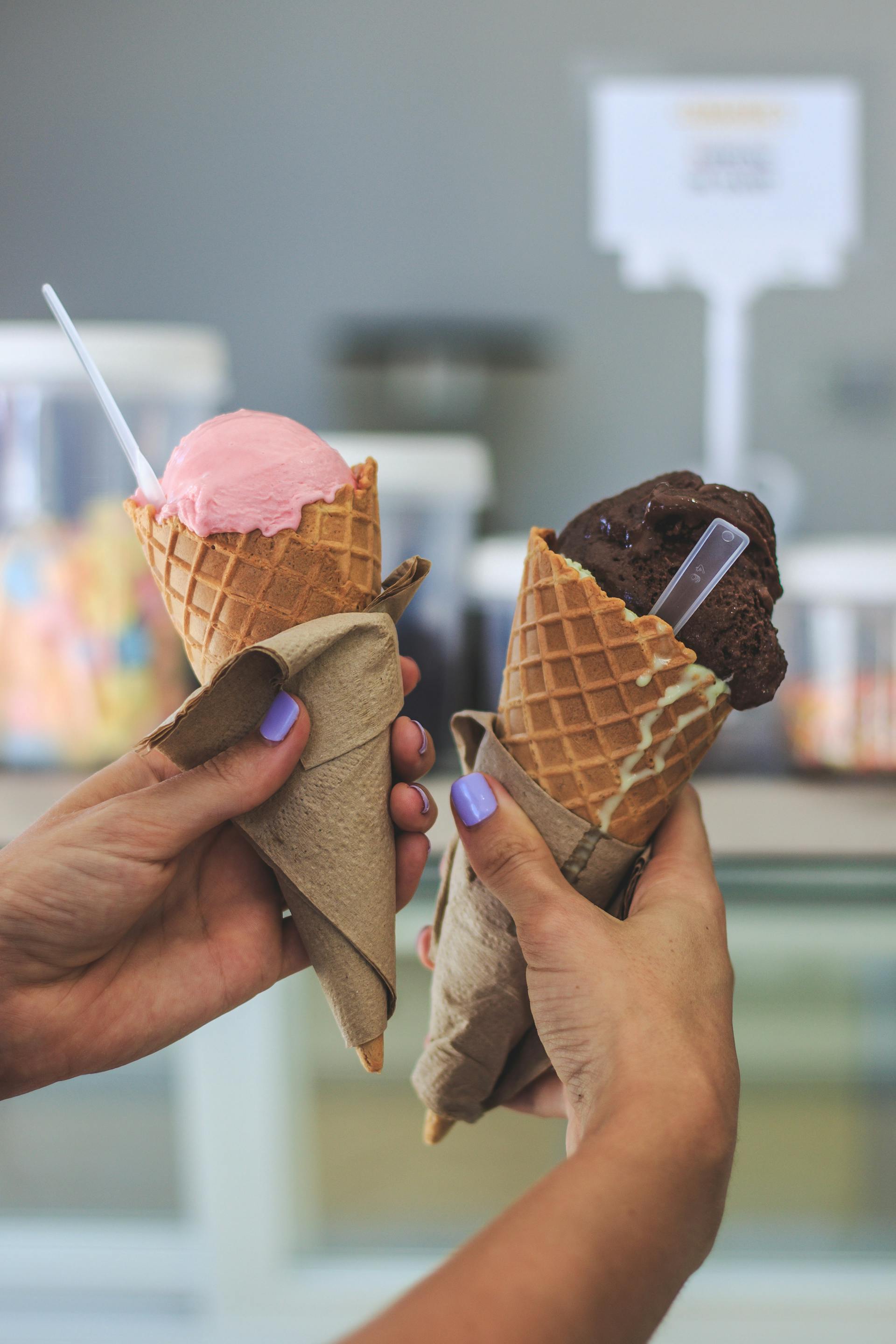 Primer plano de una mujer sujetando dos cucuruchos de helado | Fuente: Pexels