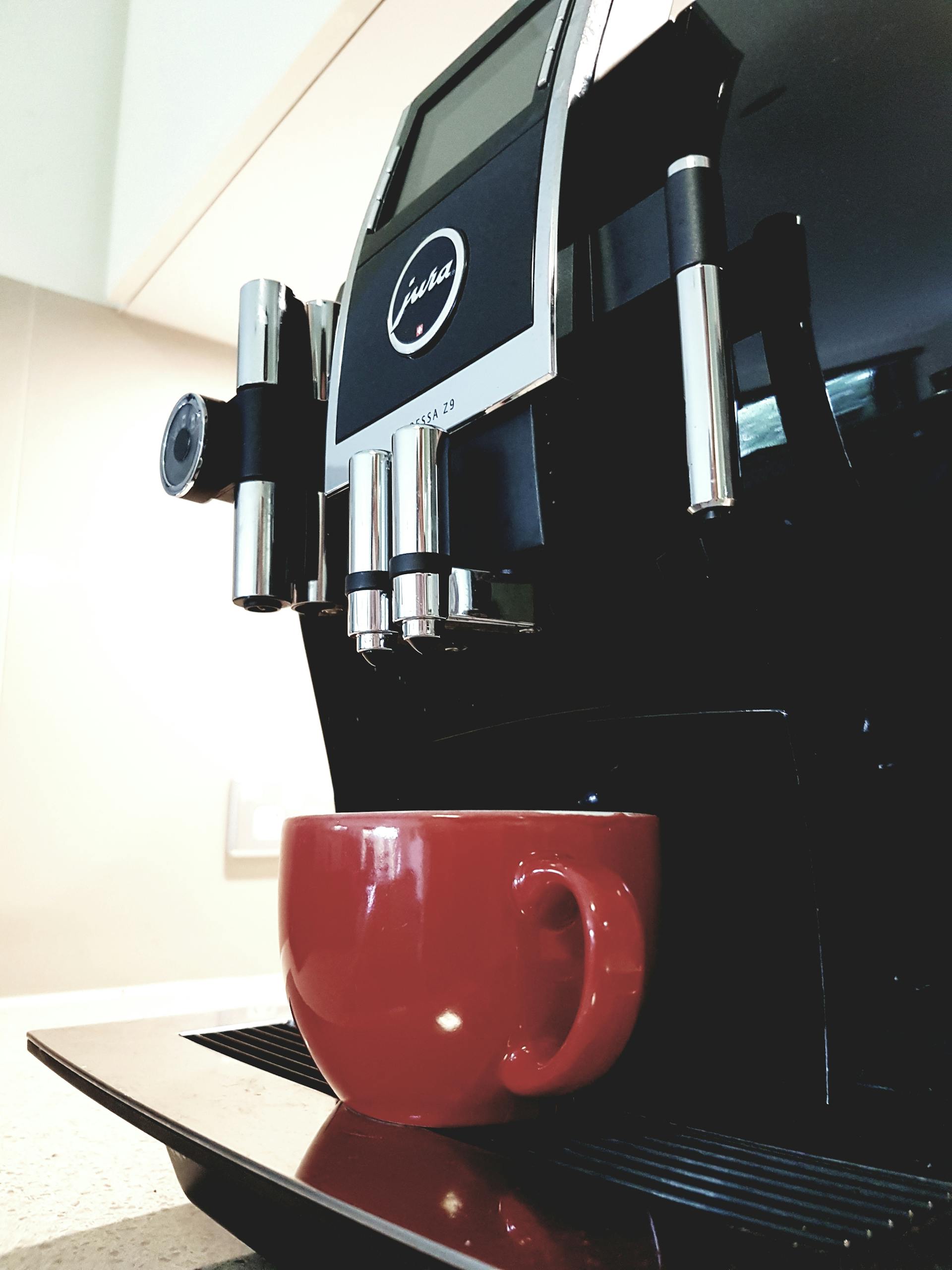 Una máquina de café con una taza roja | Fuente: Pexels