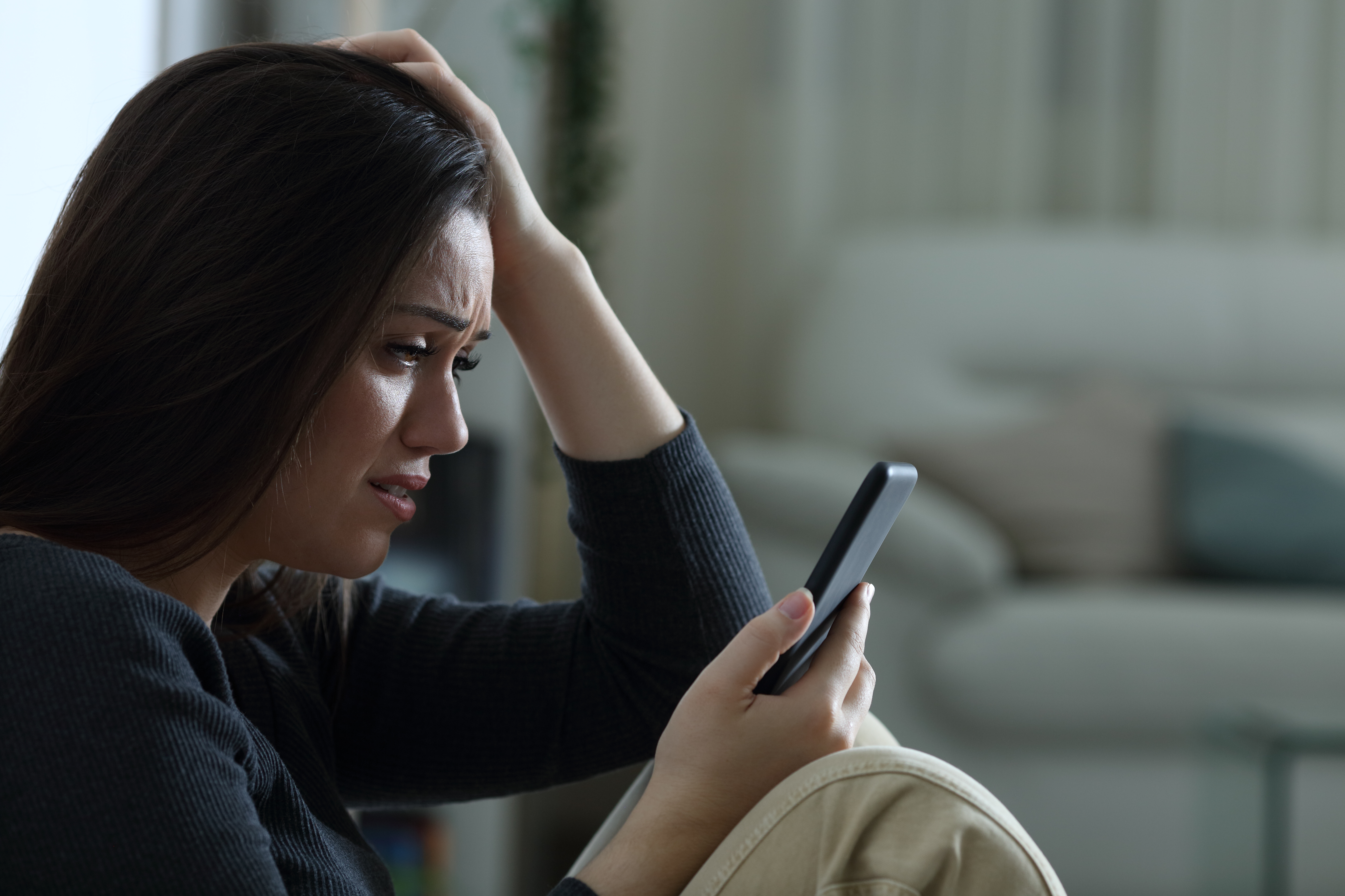 Una mujer con cara triste mientras habla por teléfono | Foto: Shutterstock