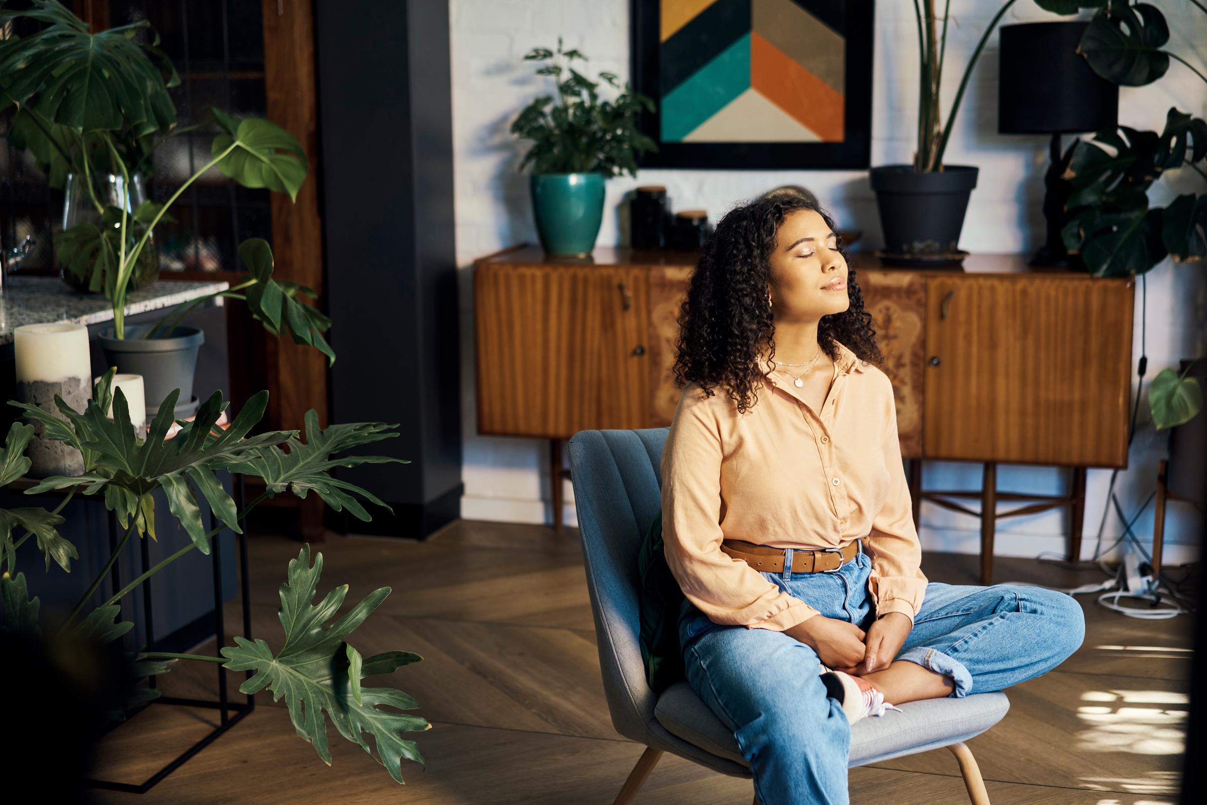 Una mujer meditando en el salón | Fuente: Getty Images