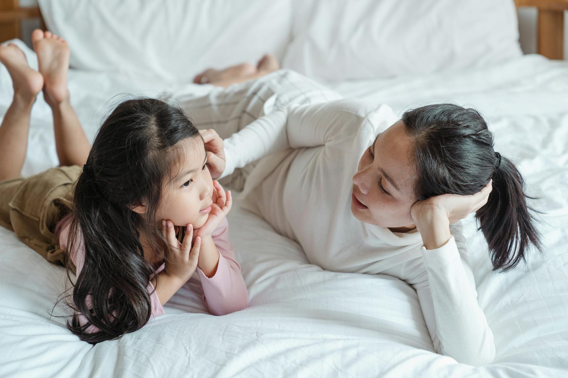 Una mujer hablando con su hija en la cama | Fuente: Pexels