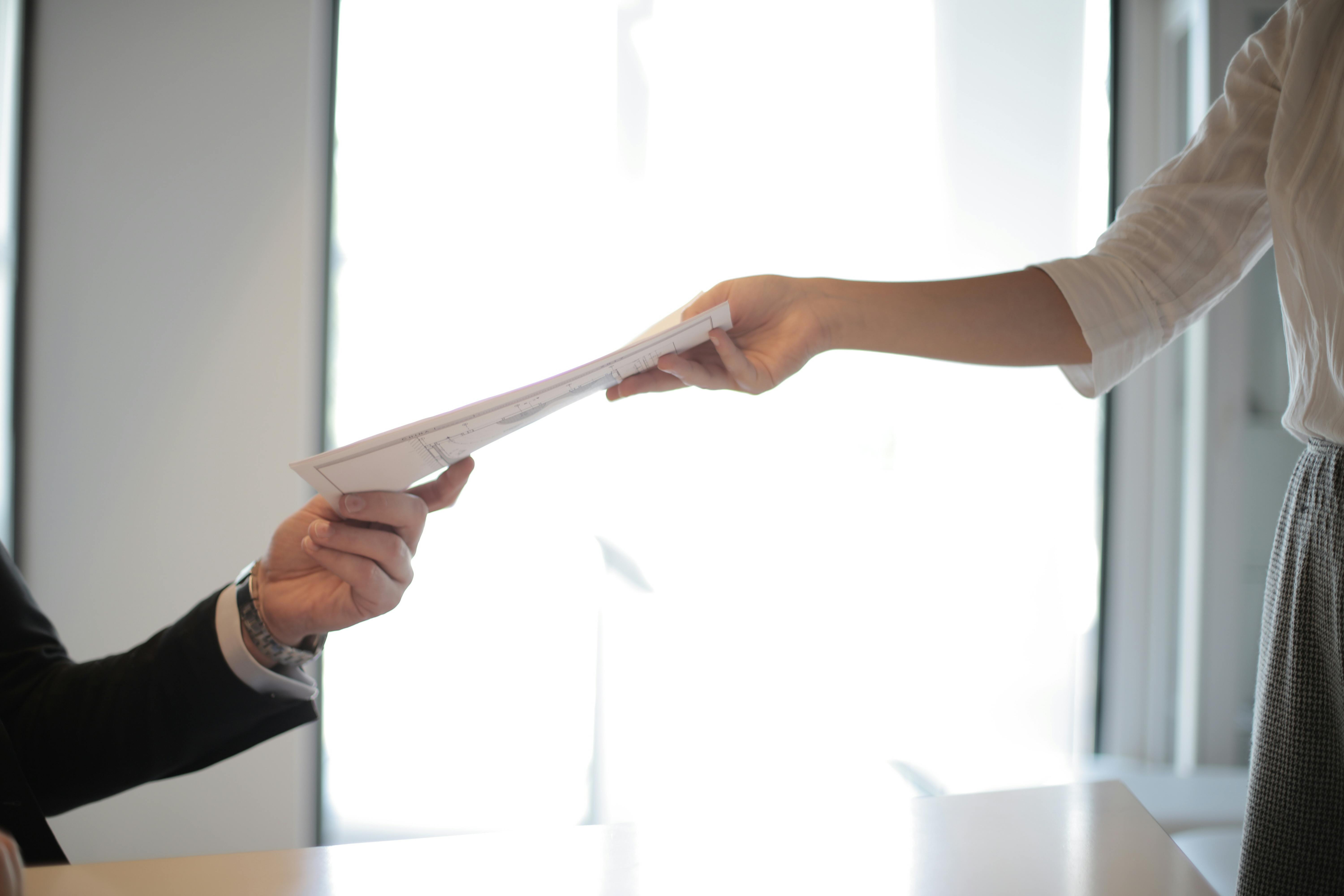 Una mujer recibiendo documentos confidenciales | Fuente: Pexels